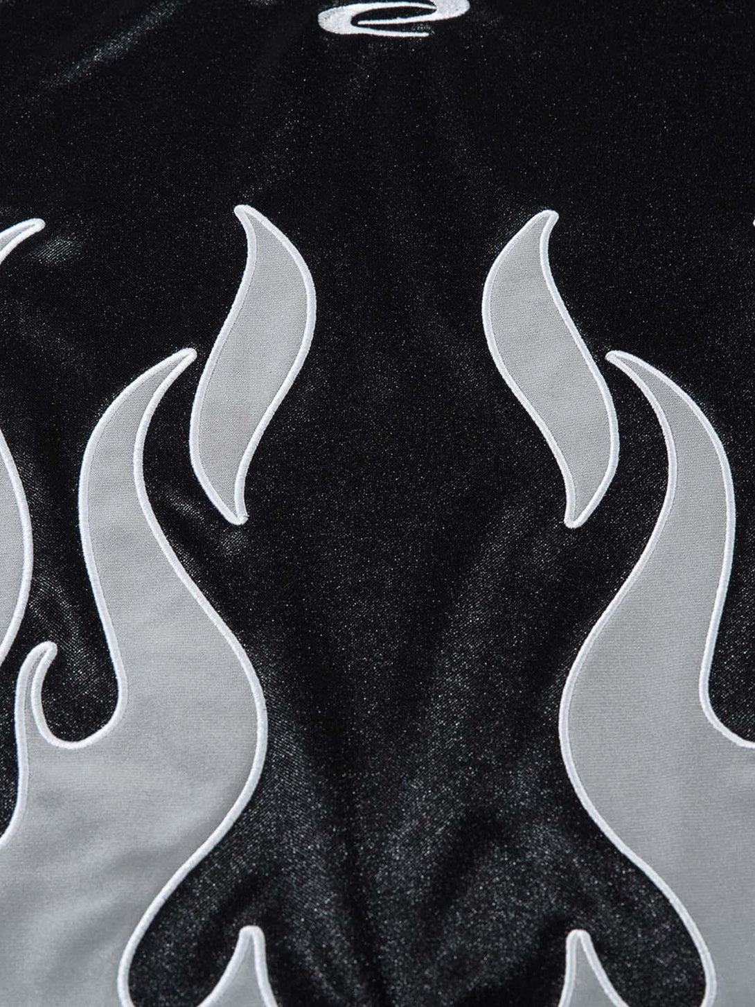 A detailed view of the flame embroidery on a black polo T-shirt by TALISHKO, highlighting bold style.