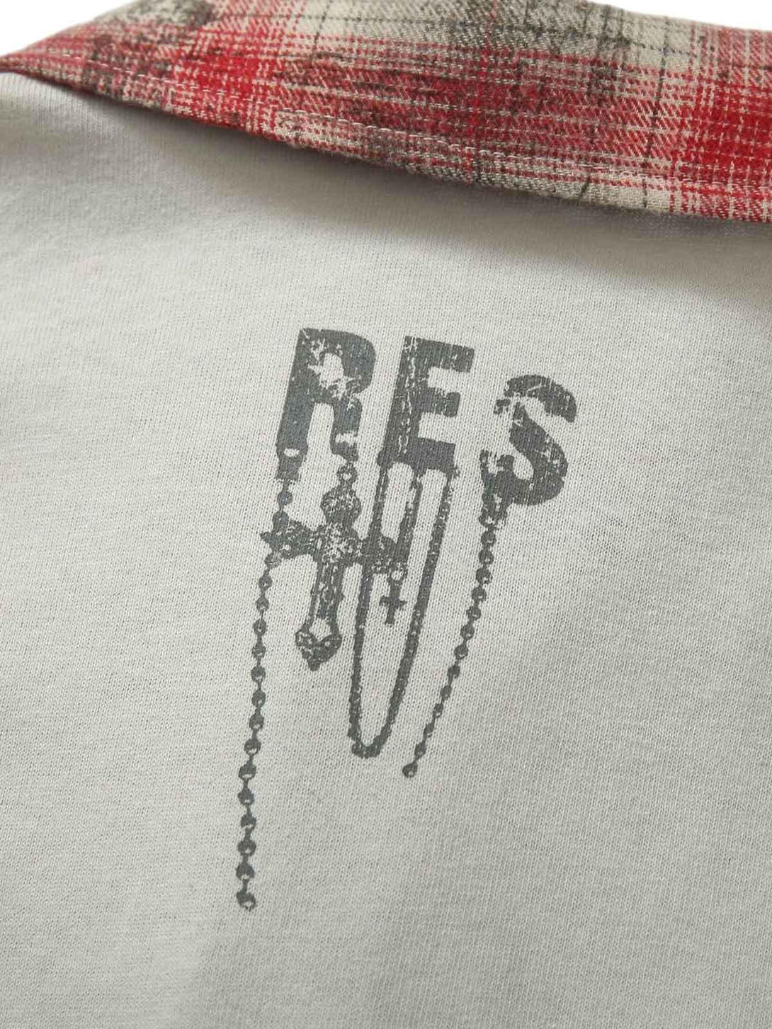 A close-up of TALISHKO polo shirt's back, highlighting graffiti design and red plaid collar.