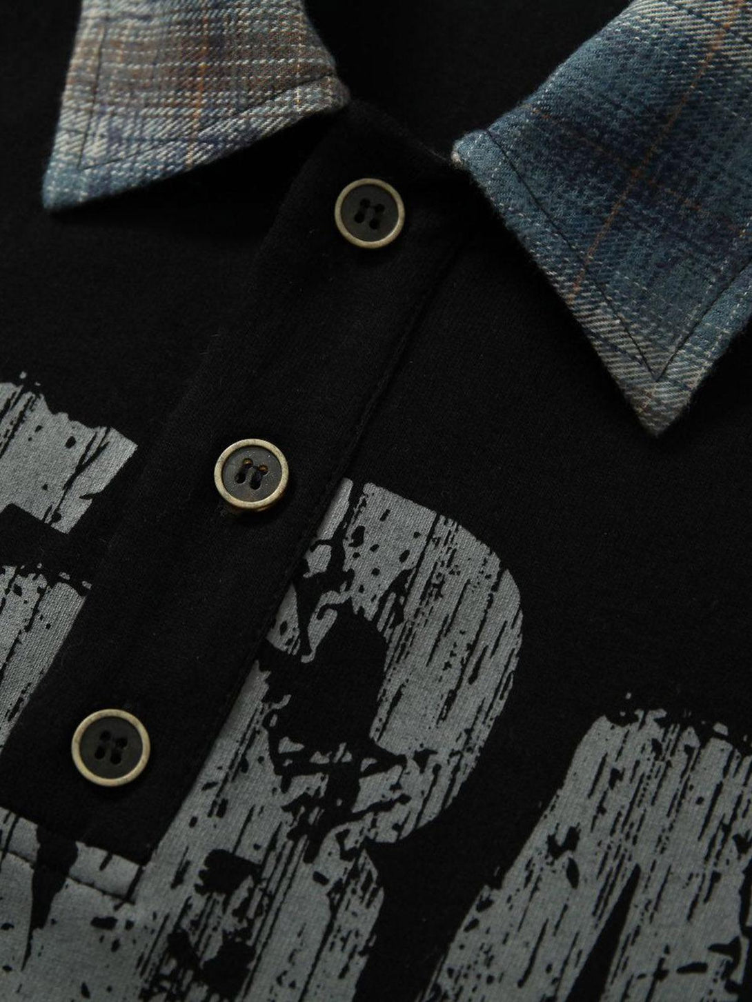 A close-up of TALISHKO polo shirt's buttons and plaid collar, highlighting graffiti design.