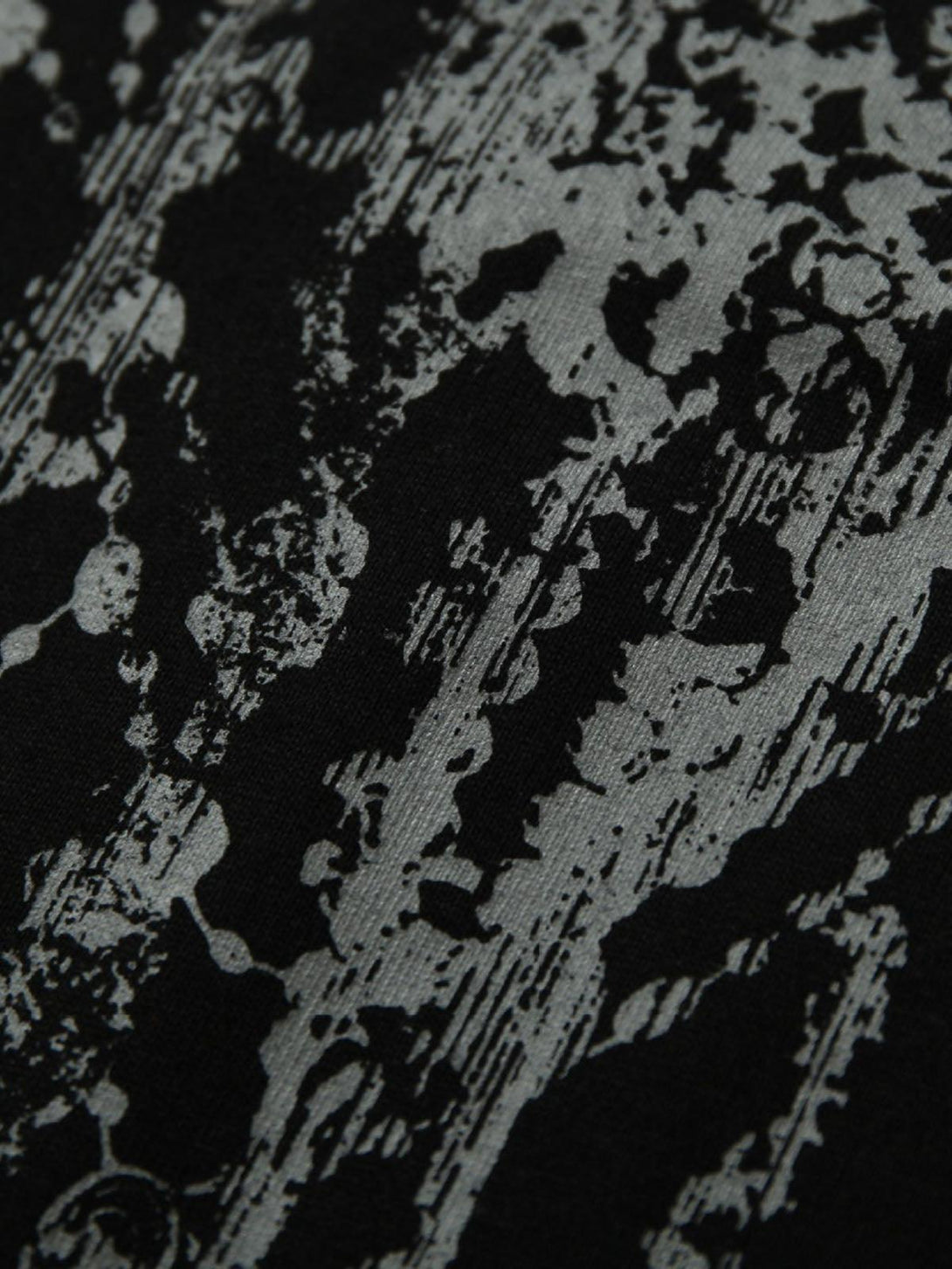 "Zoomed-in texture of TALISHKO polo shirt showcasing its unique graffiti-inspired design."