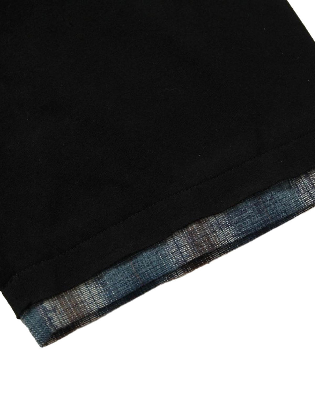 "Zoomed-in view of TALISHKO polo shirt's hem with plaid lining, highlighting layered style."