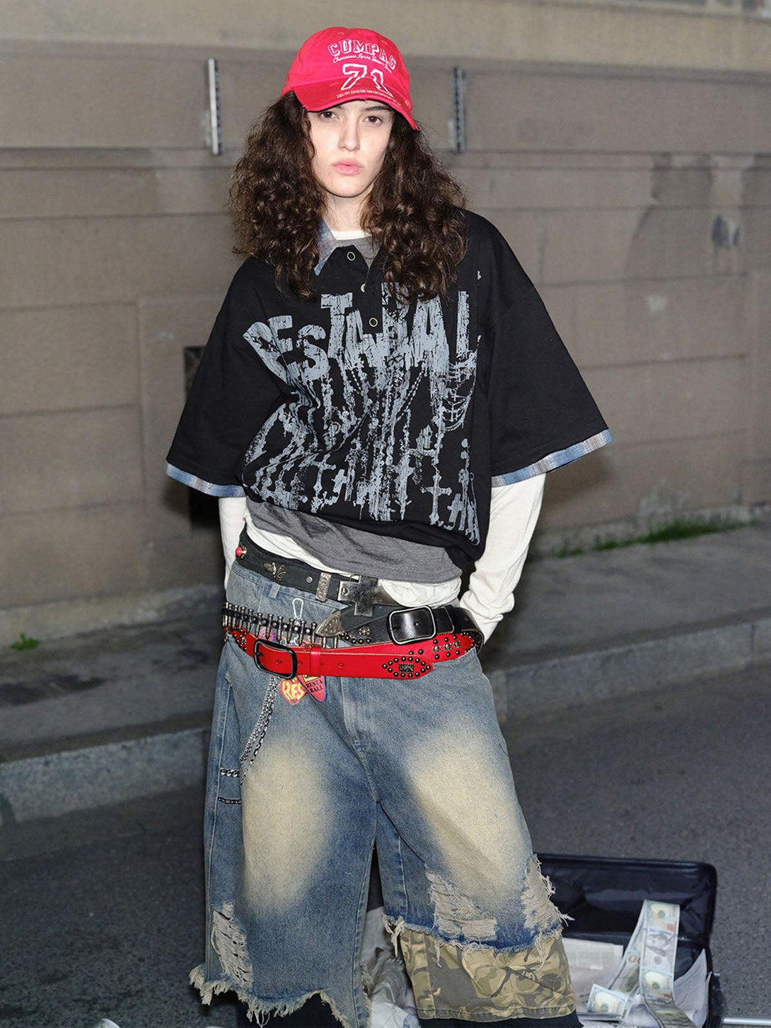 Model wearing TALISHKO street-style polo with graffiti design and layered urban outfit.