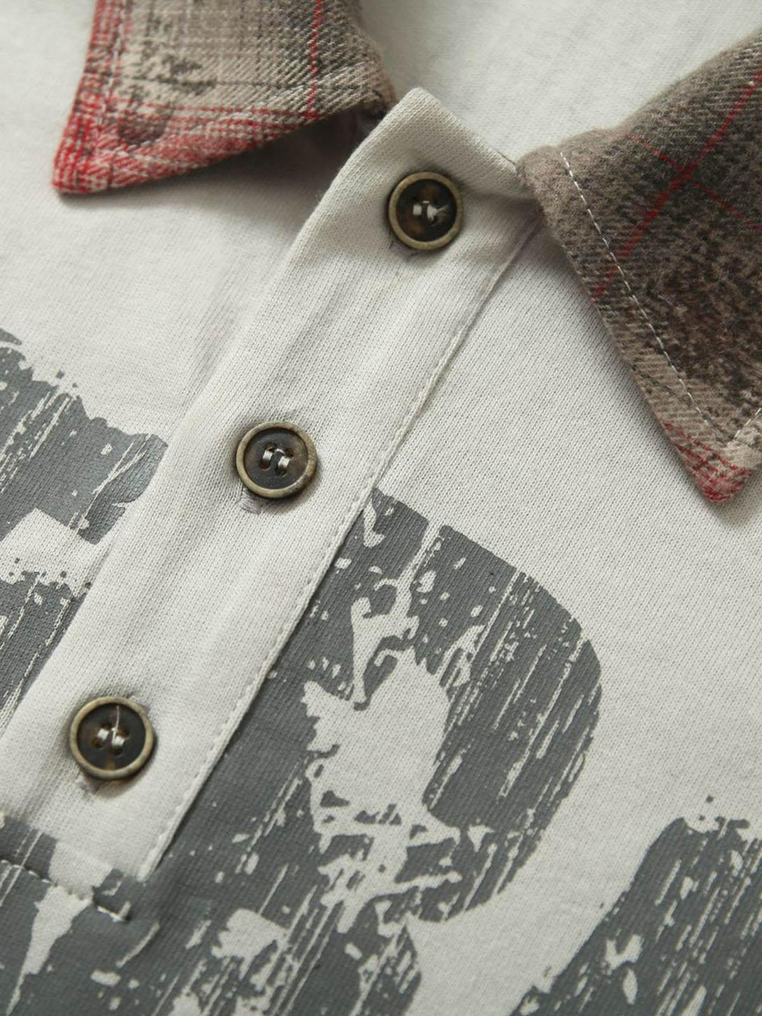 "Intricate look at TALISHKO polo's button detail and plaid collar with graffiti print."