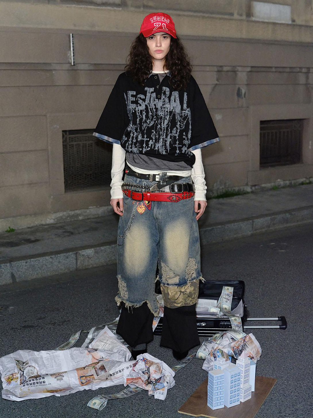 Model in TALISHKO graffiti polo shirt over layered streetwear, set against an urban backdrop.