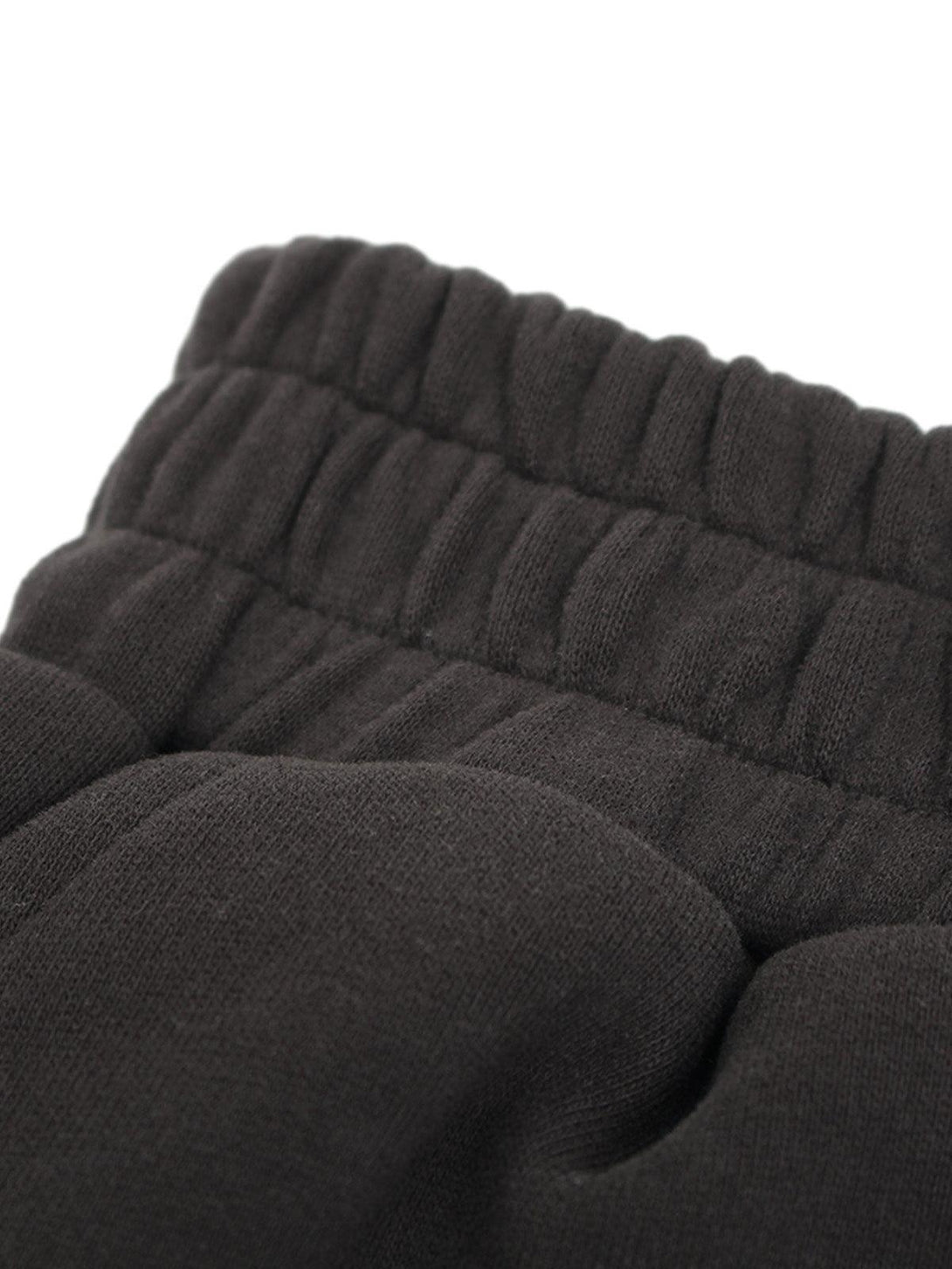 Intricate look at TALISHKO drawstring shorts, showcasing textured waistband and fabric detail.