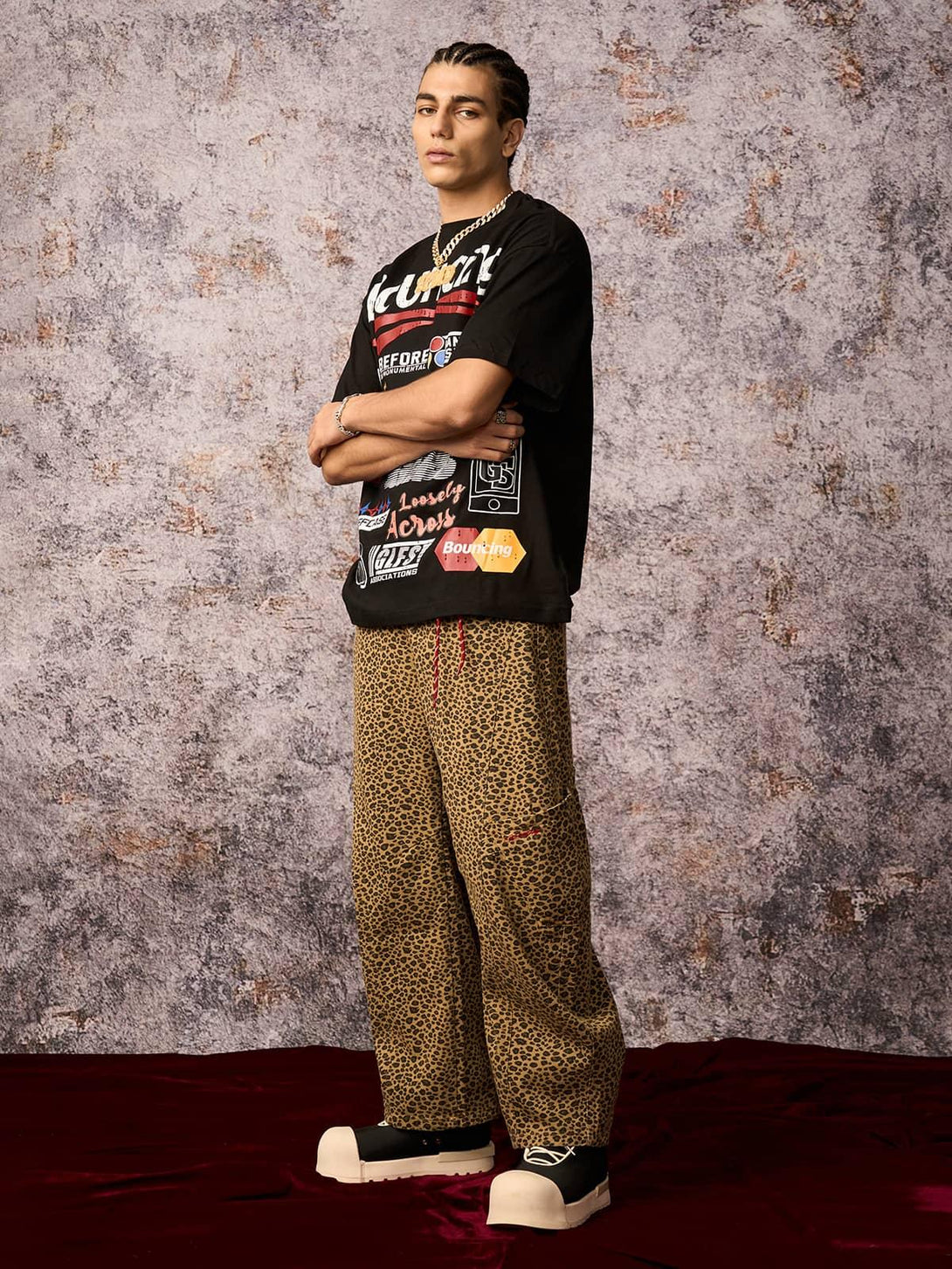 Model in a TALISHKO street graphic T-shirt and leopard pants, embodying bold urban fashion.
