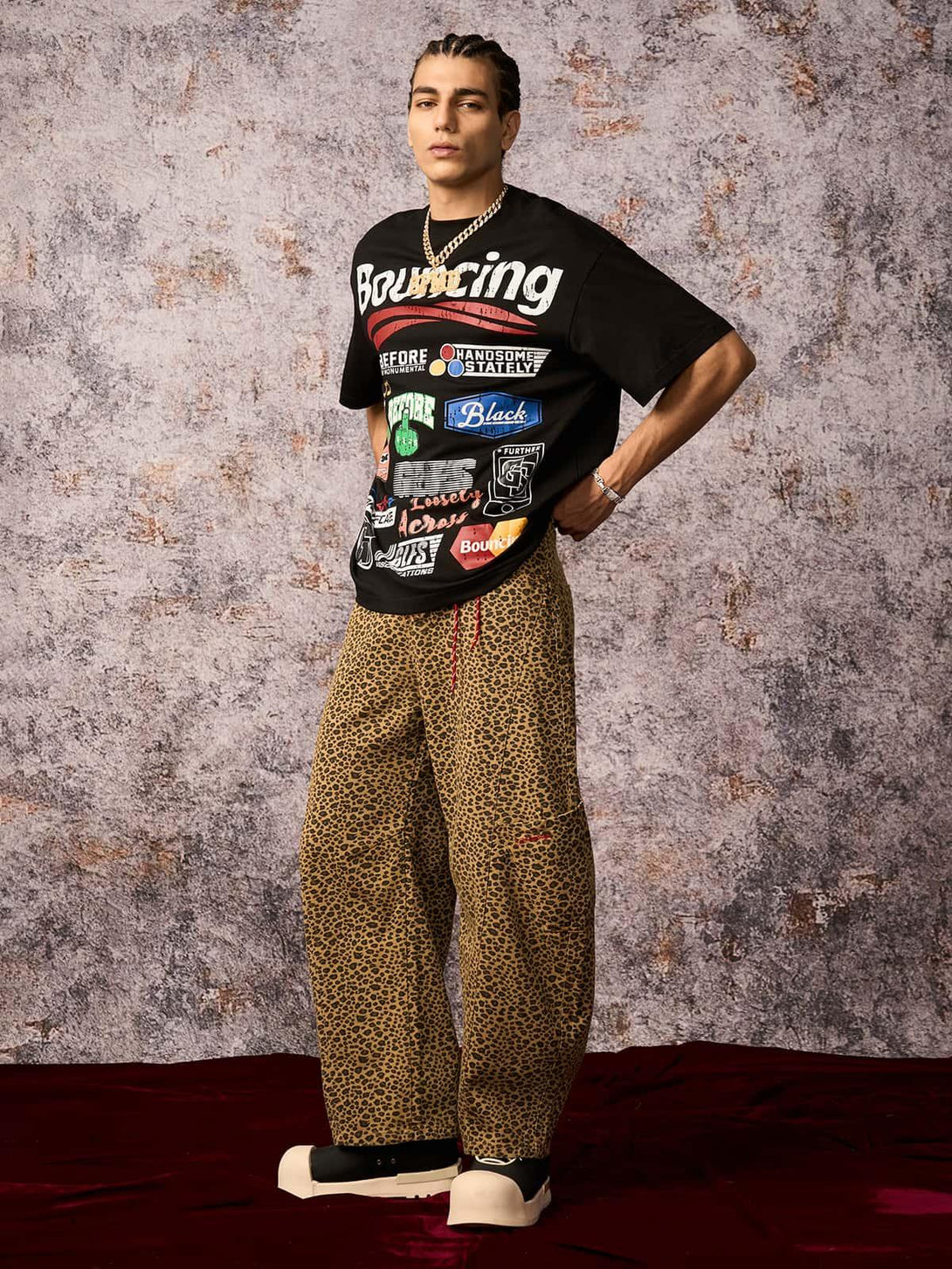 Model styled in a TALISHKO street graphic T-shirt and leopard pants, exuding a bold urban vibe.