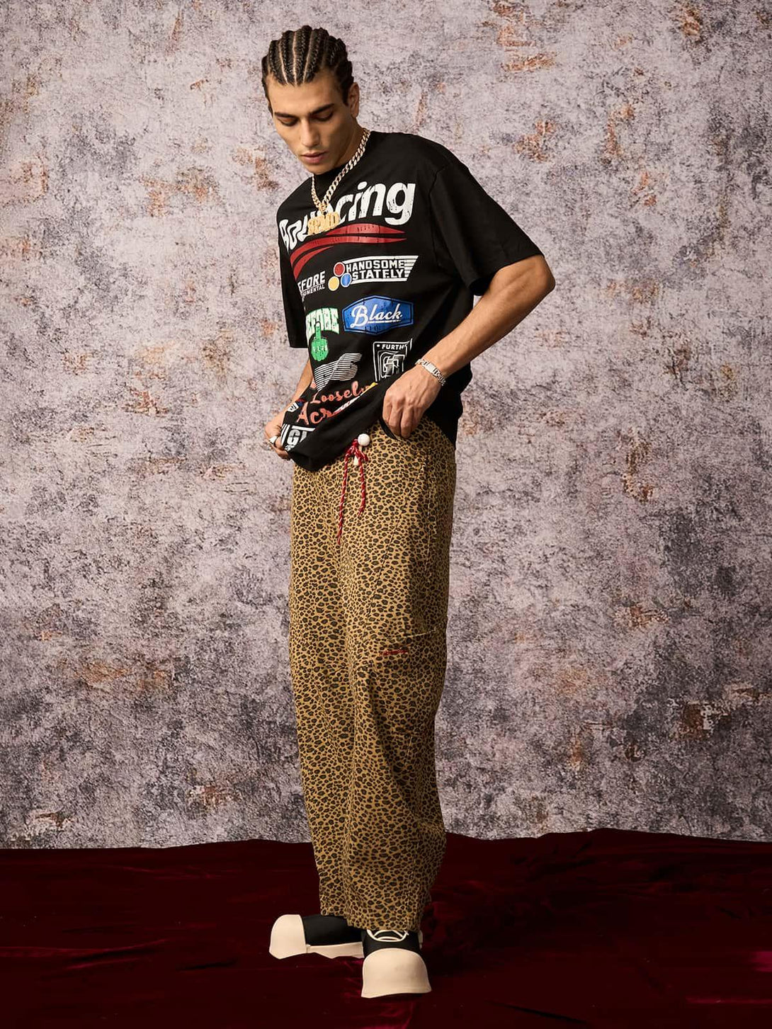 Model styled in TALISHKO graphic print T-shirt with leopard pants, capturing an urban summer vibe.