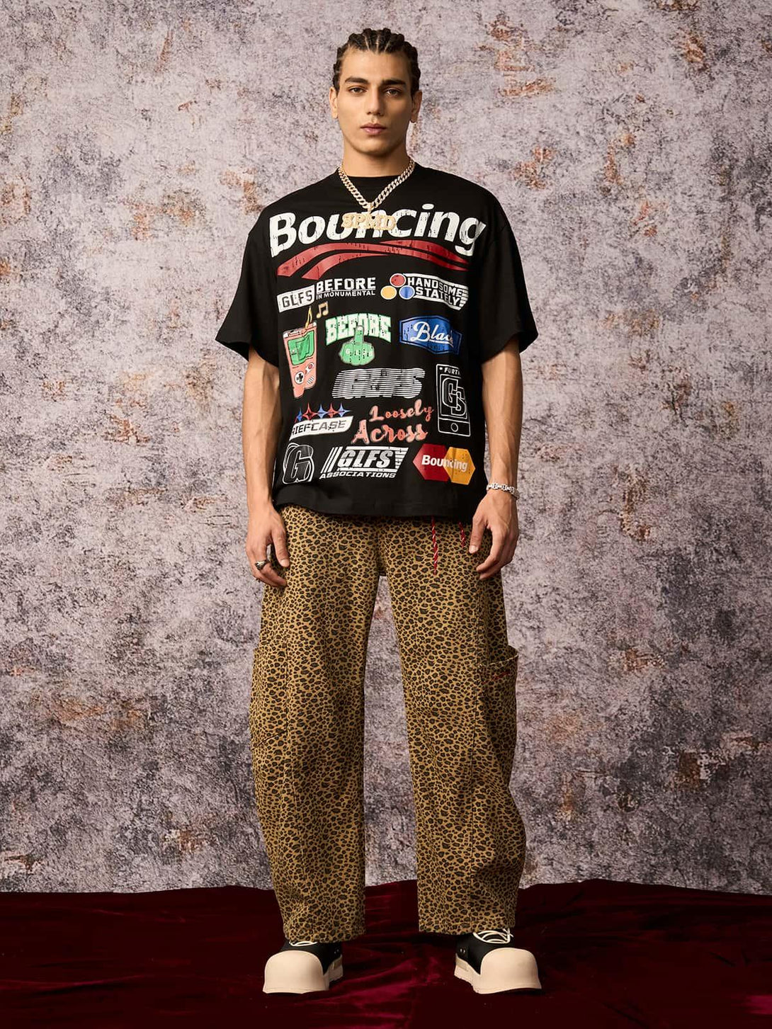 Model wearing a TALISHKO street graphic print T-shirt with leopard print pants, exuding urban style.