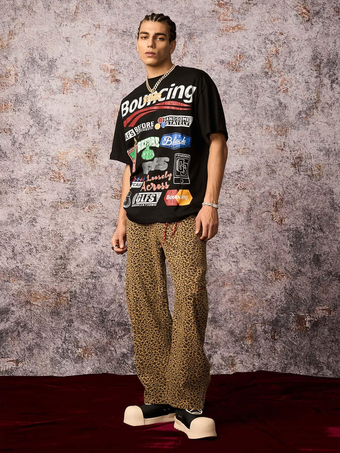 Model wearing a TALISHKO street graphic T-shirt and leopard pants, showcasing edgy urban flair.