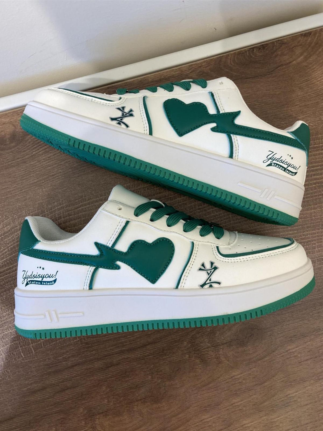 TALISHKO skate shoes in green and white with heart design, adding a playful streetwear touch.