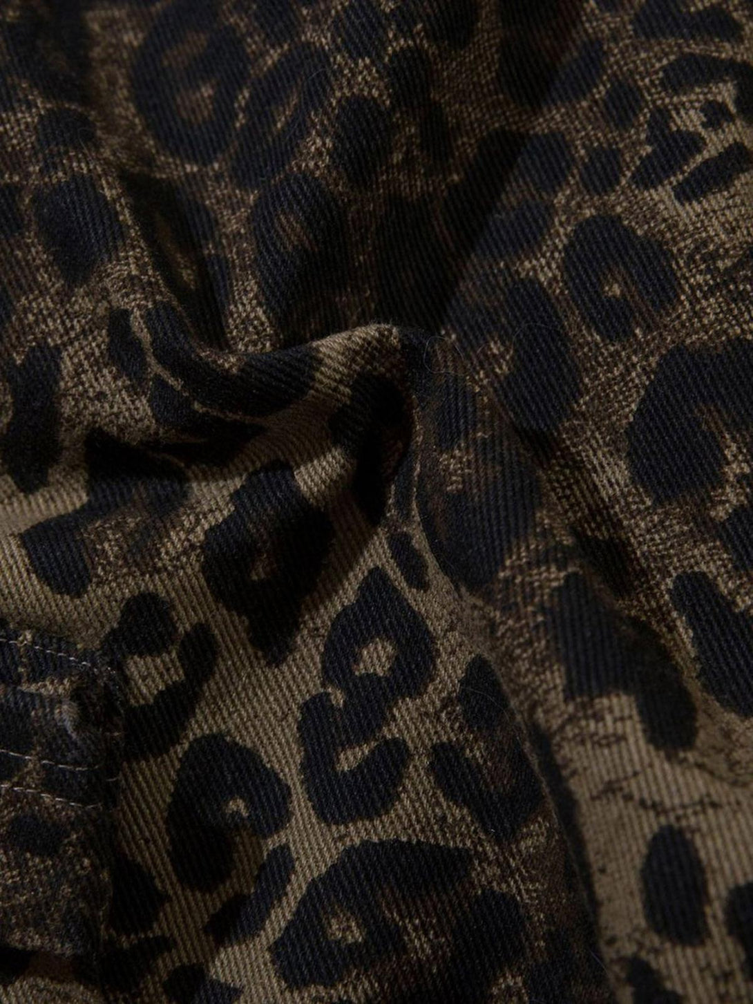 Zoomed-in texture of TALISHKO leopard print shorts, highlighting the intricate fabric pattern.