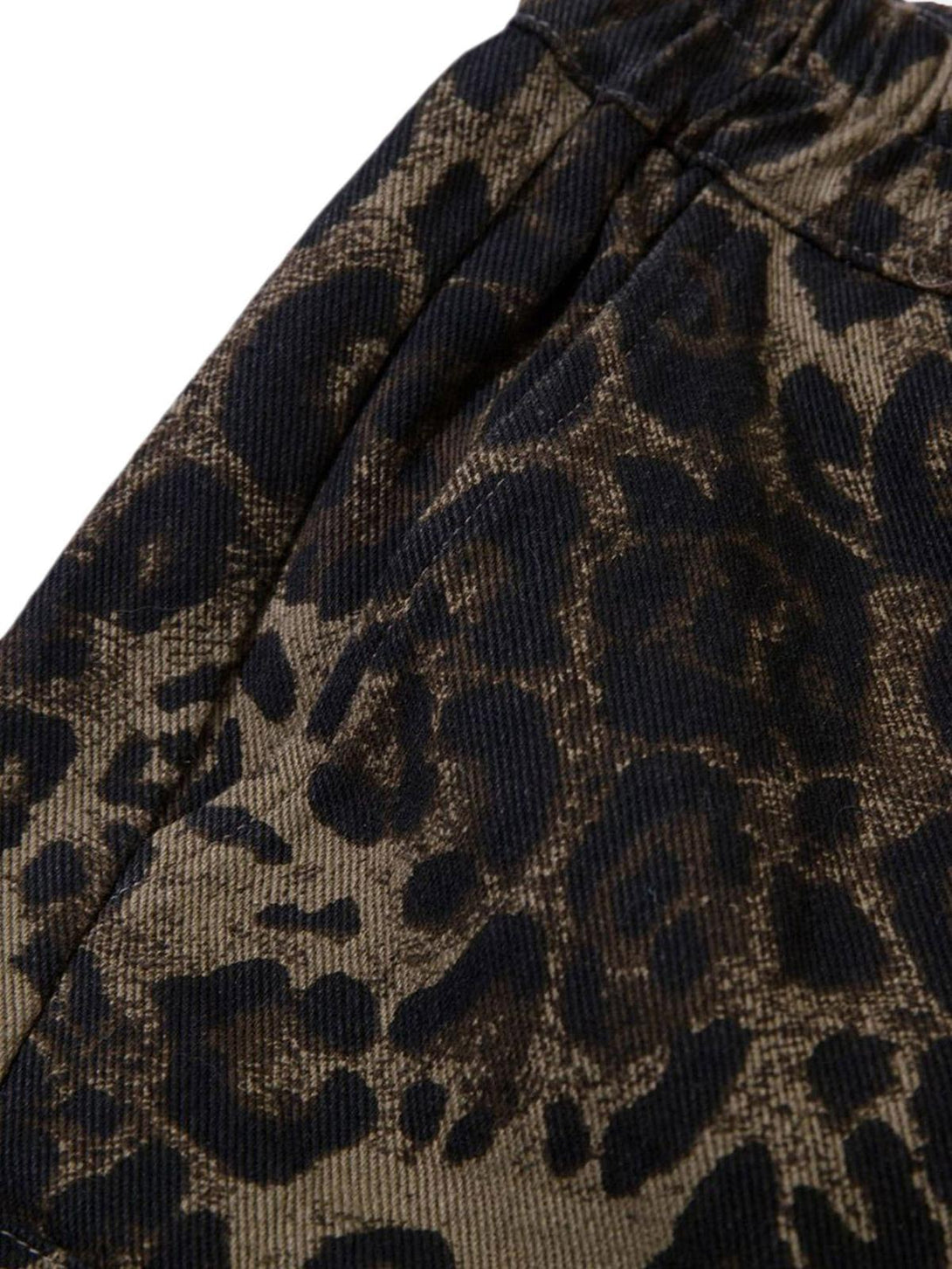 A close-up of TALISHKO leopard print shorts, highlighting the textured fabric and bold design.