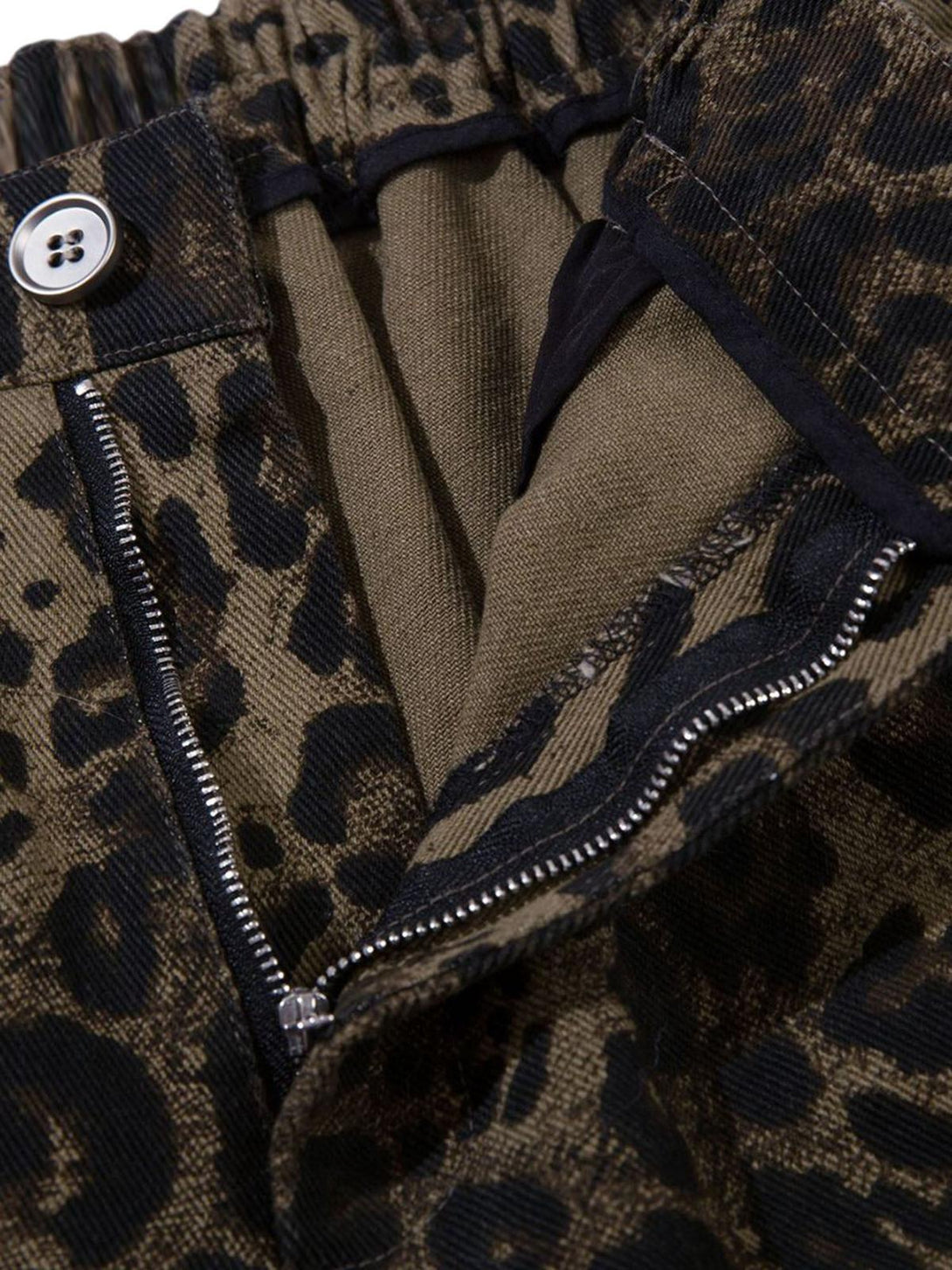 Intricate look at TALISHKO leopard print shorts, showcasing detailed fabric and zipper design.