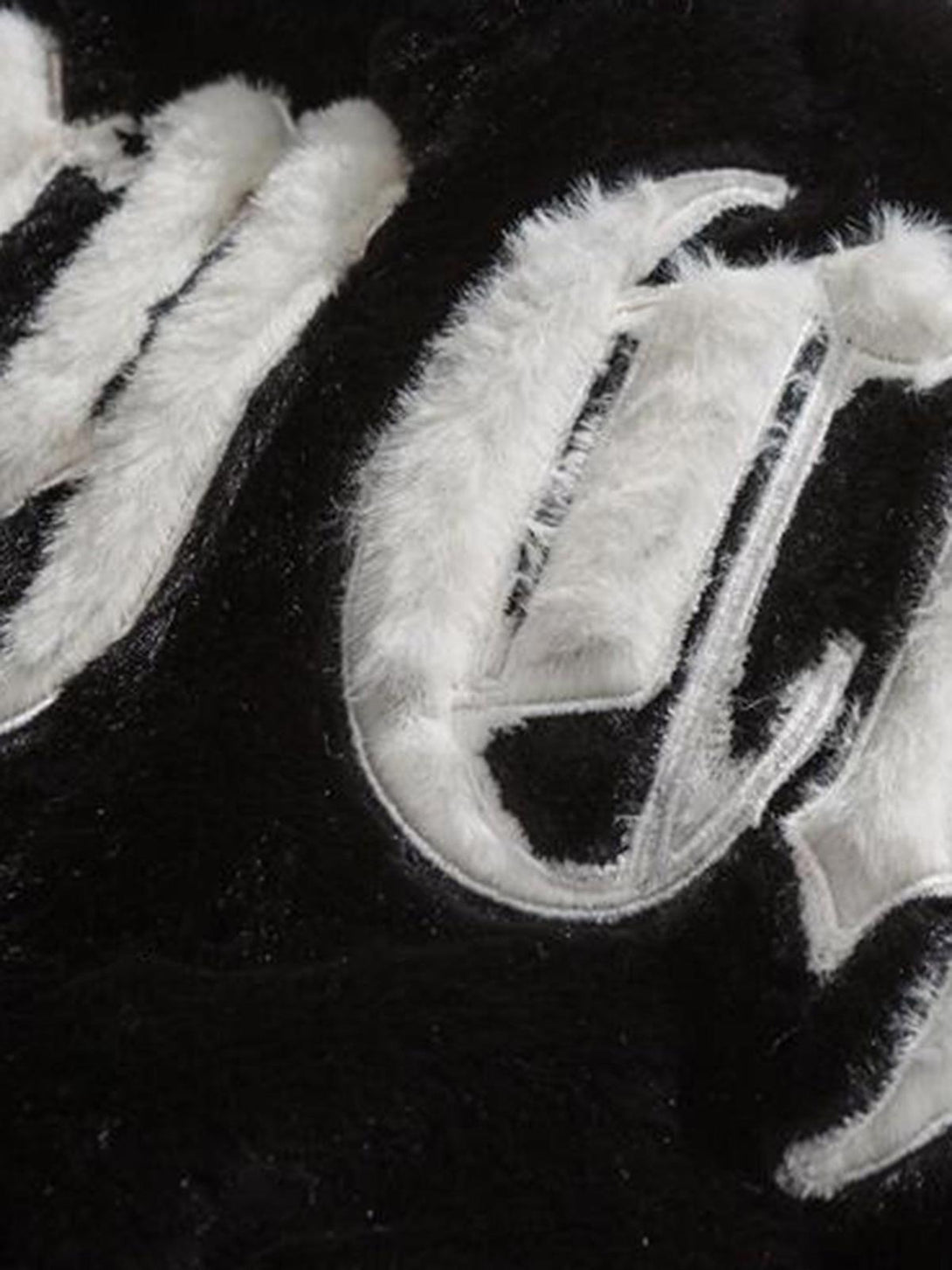 Intricate look at TALISHKO's fleece jacket, highlighting bold street-inspired embroidery.