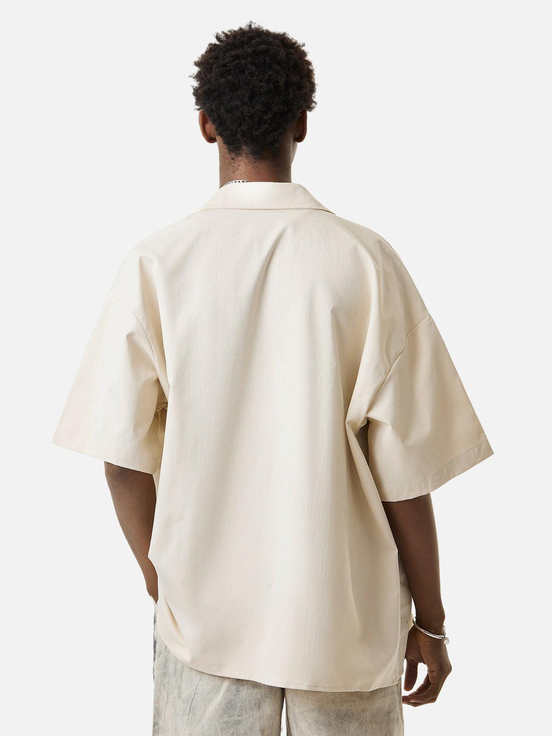 Back view of TALISHKO short sleeve shirt in a neutral shade, showcasing relaxed fit style.