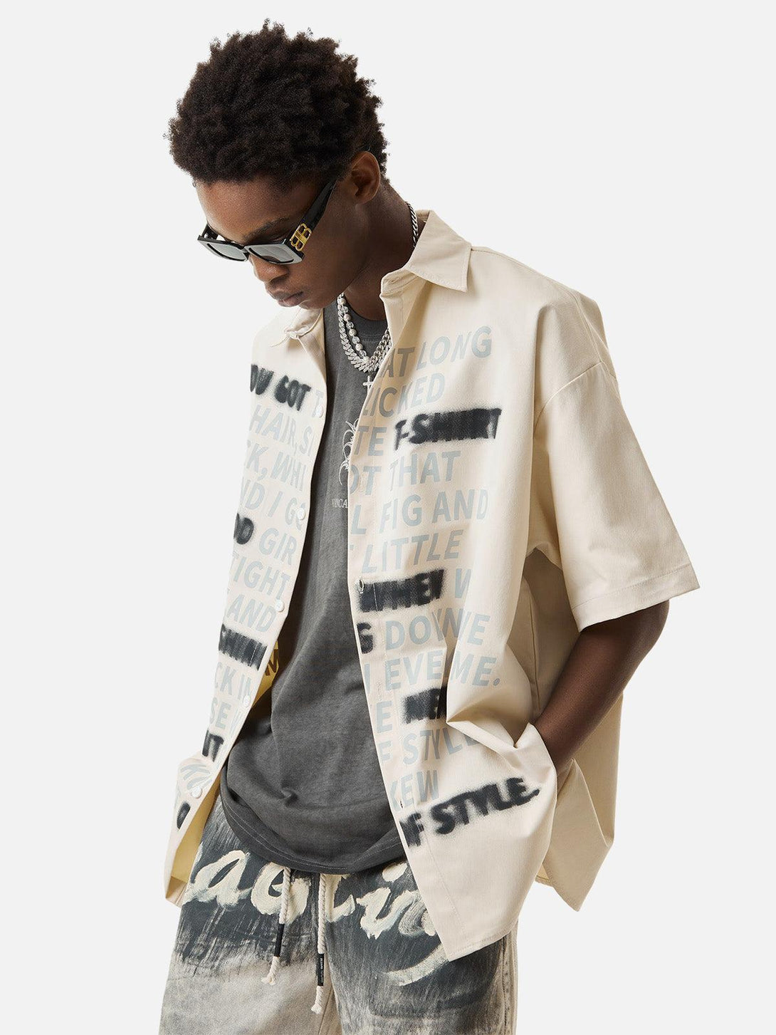 Model styled in TALISHKO letter print shirt, paired with sunglasses and layered necklaces.