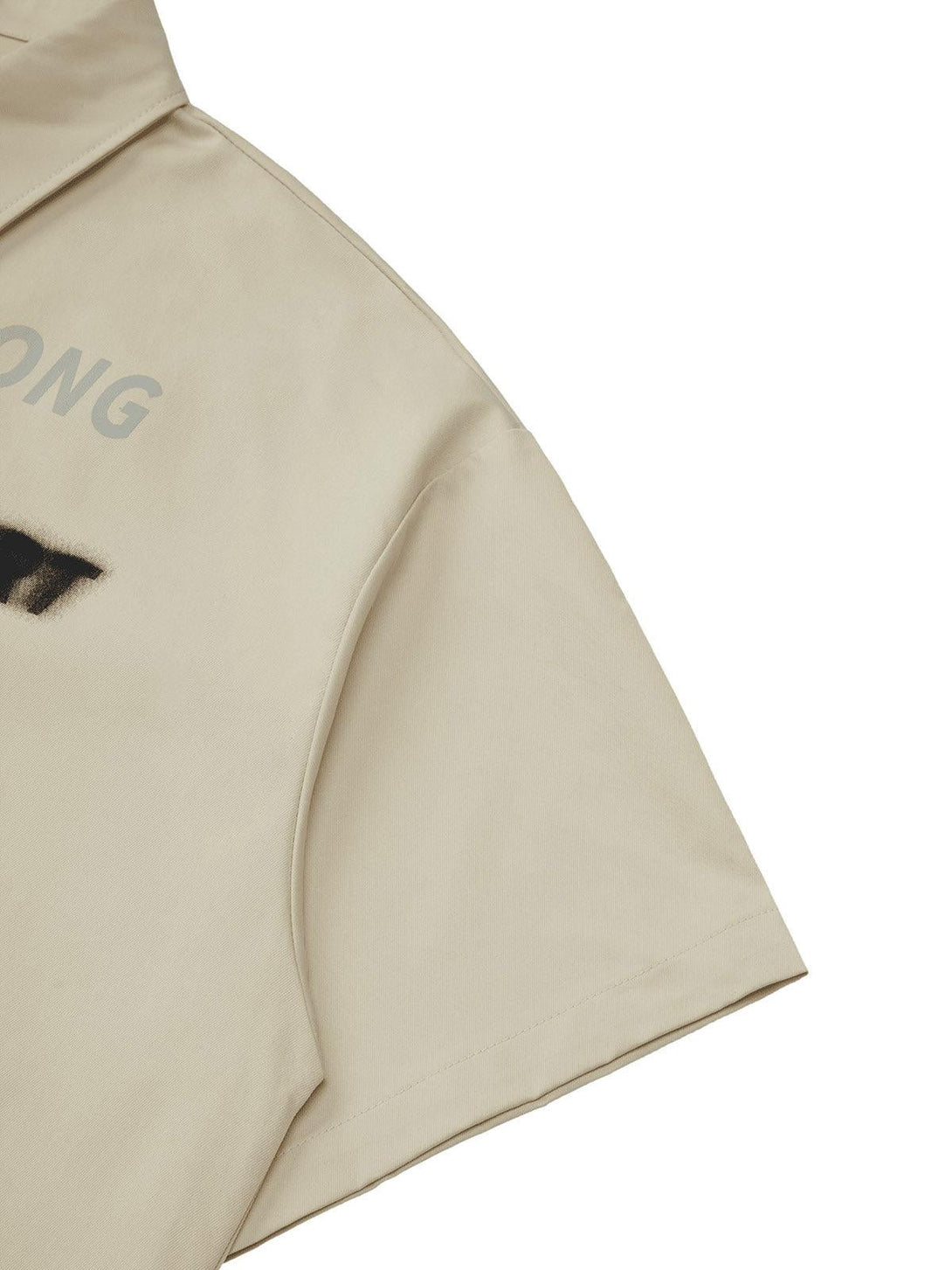 Focusing on the TALISHKO shirt's detailed stitching and letter print on the sleeve.