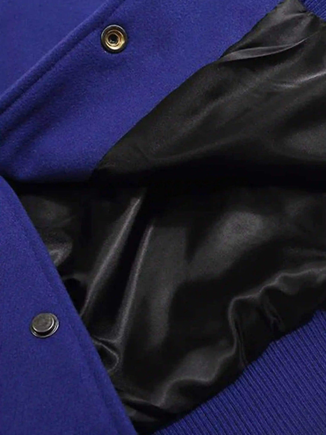 A detailed view of TALISHKO's baseball jacket, highlighting black satin lining and buttons.
