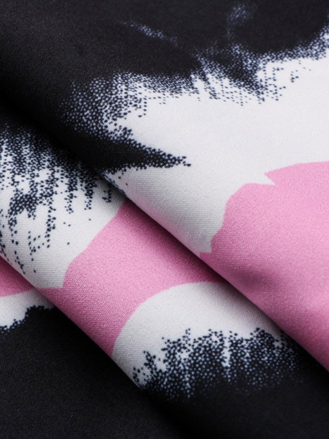 Zoomed-in texture of TALISHKO's shirt showcasing pink and white abstract patterns on fabric.