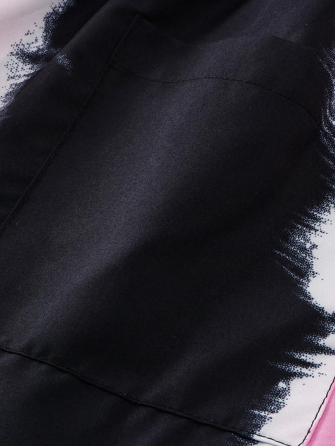 A tight crop highlighting TALISHKO's shirt fabric with abstract black and white patterns.