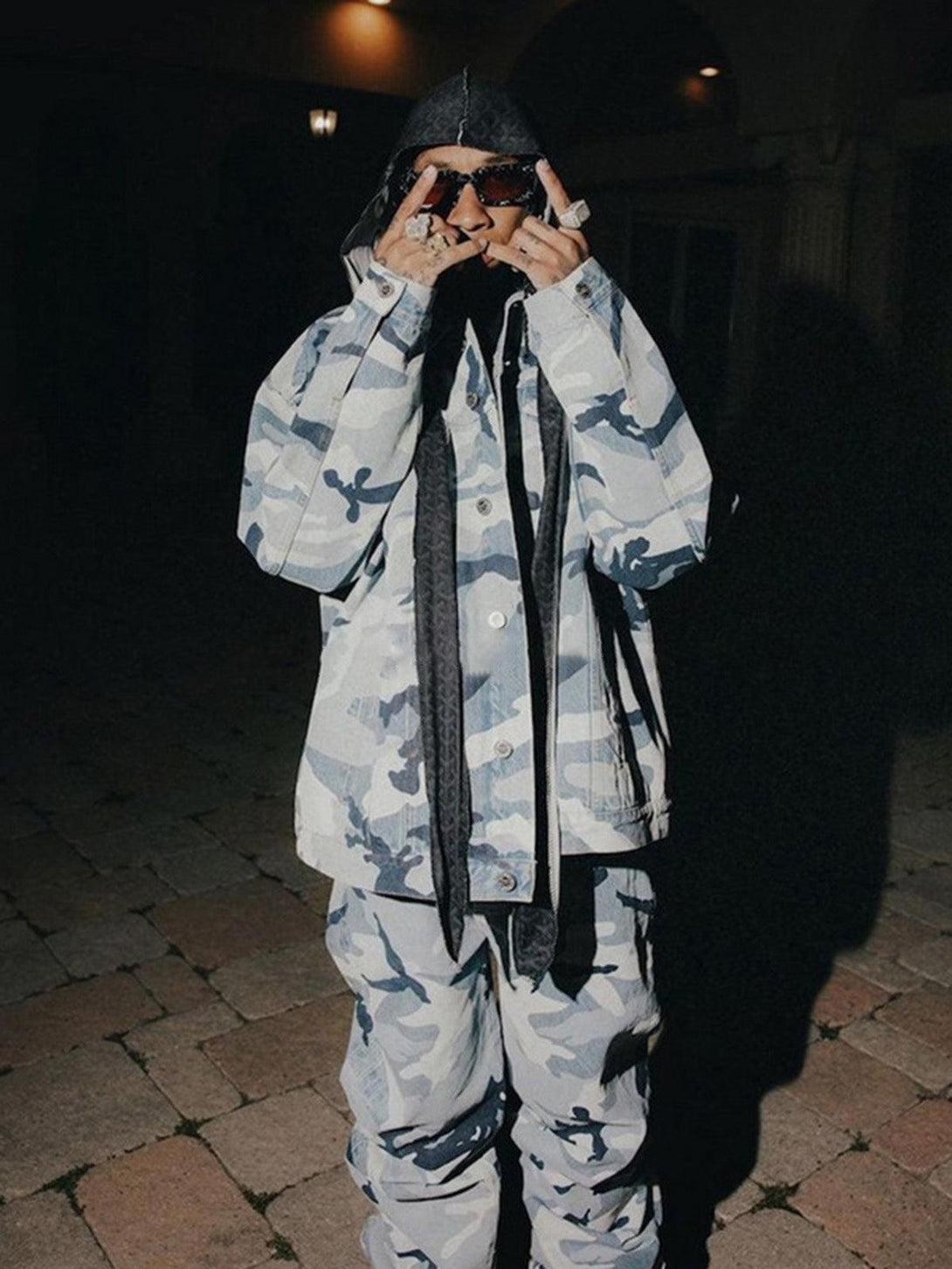 Model in blue camouflage baggy jeans and jacket by TALISHKO, embracing bold streetwear style.