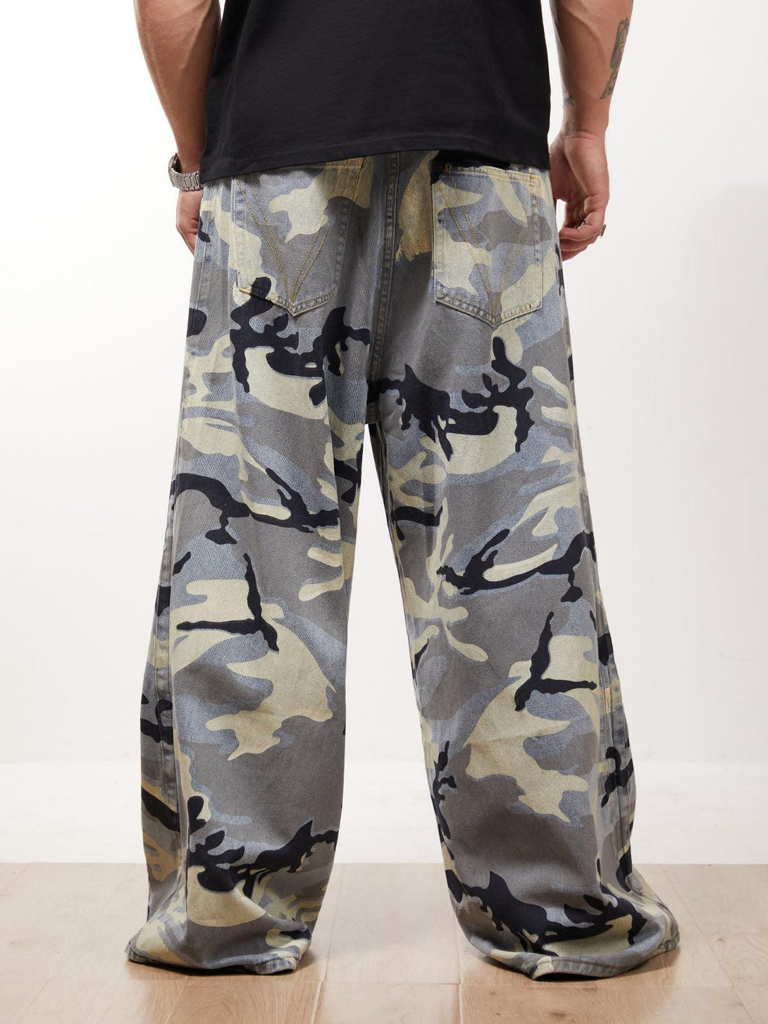 Back view of camouflage baggy jeans by TALISHKO, showcasing streetwear style with a relaxed fit.