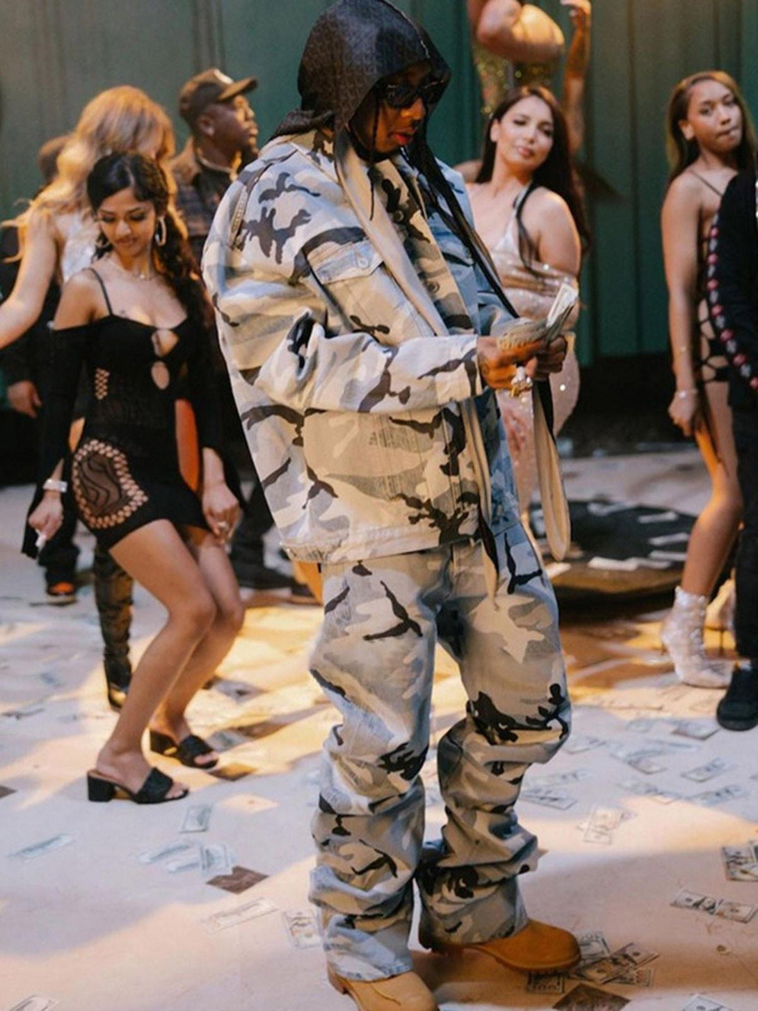 TALISHKO camouflage baggy jeans in a lively party scene, embodying urban street style.