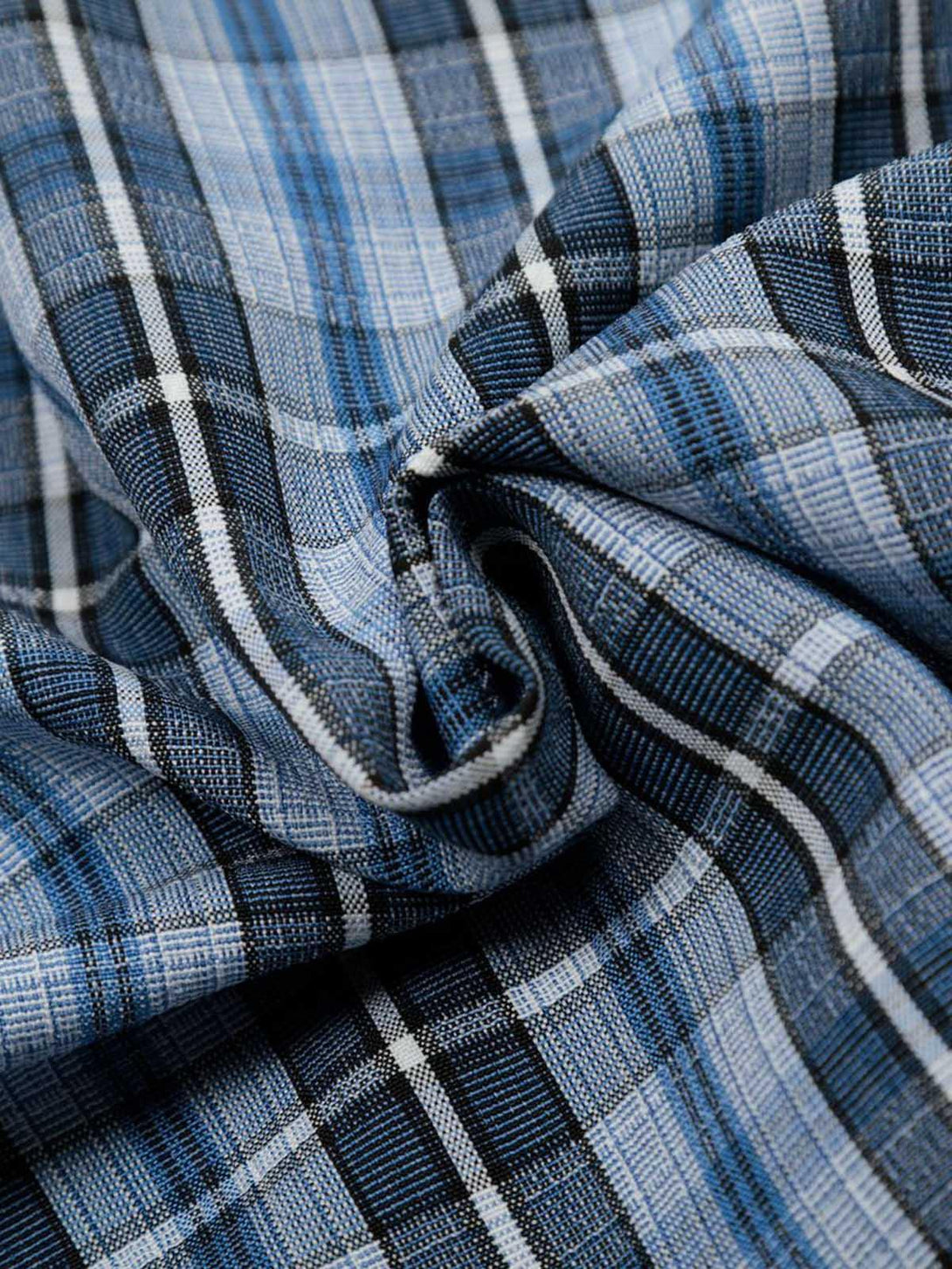 Intricate look at TALISHKO's plaid shirt, highlighting the blue and black checkered texture.