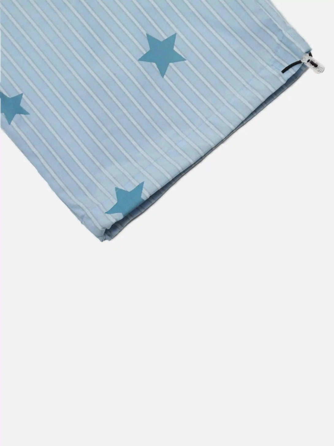 A close-up of TALISHKO trousers highlighting blue star and stripe pattern with a zip detail.