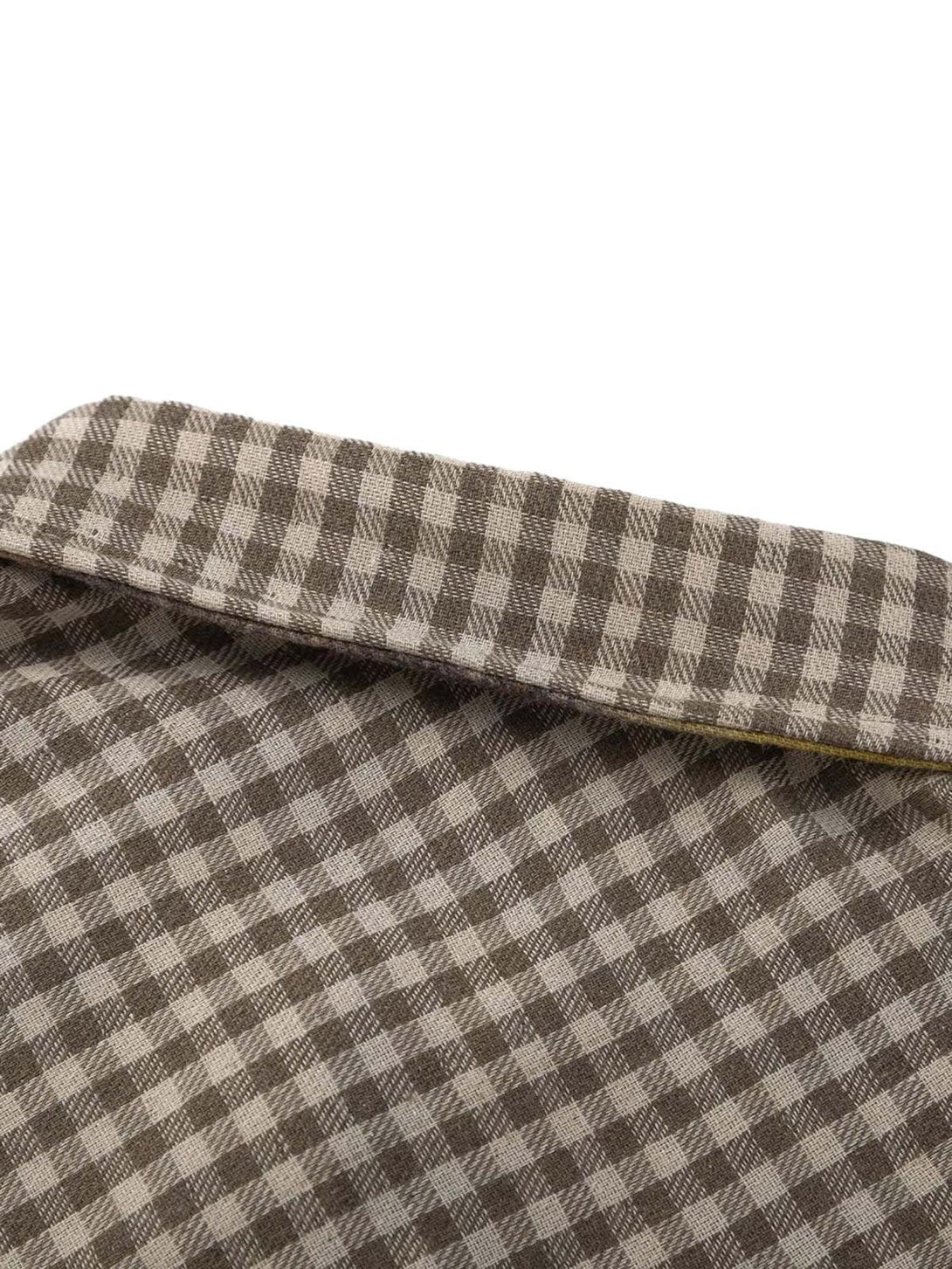Detailed fabric and stitching of a checkered reversible shirt by TALISHKO, highlighting texture.