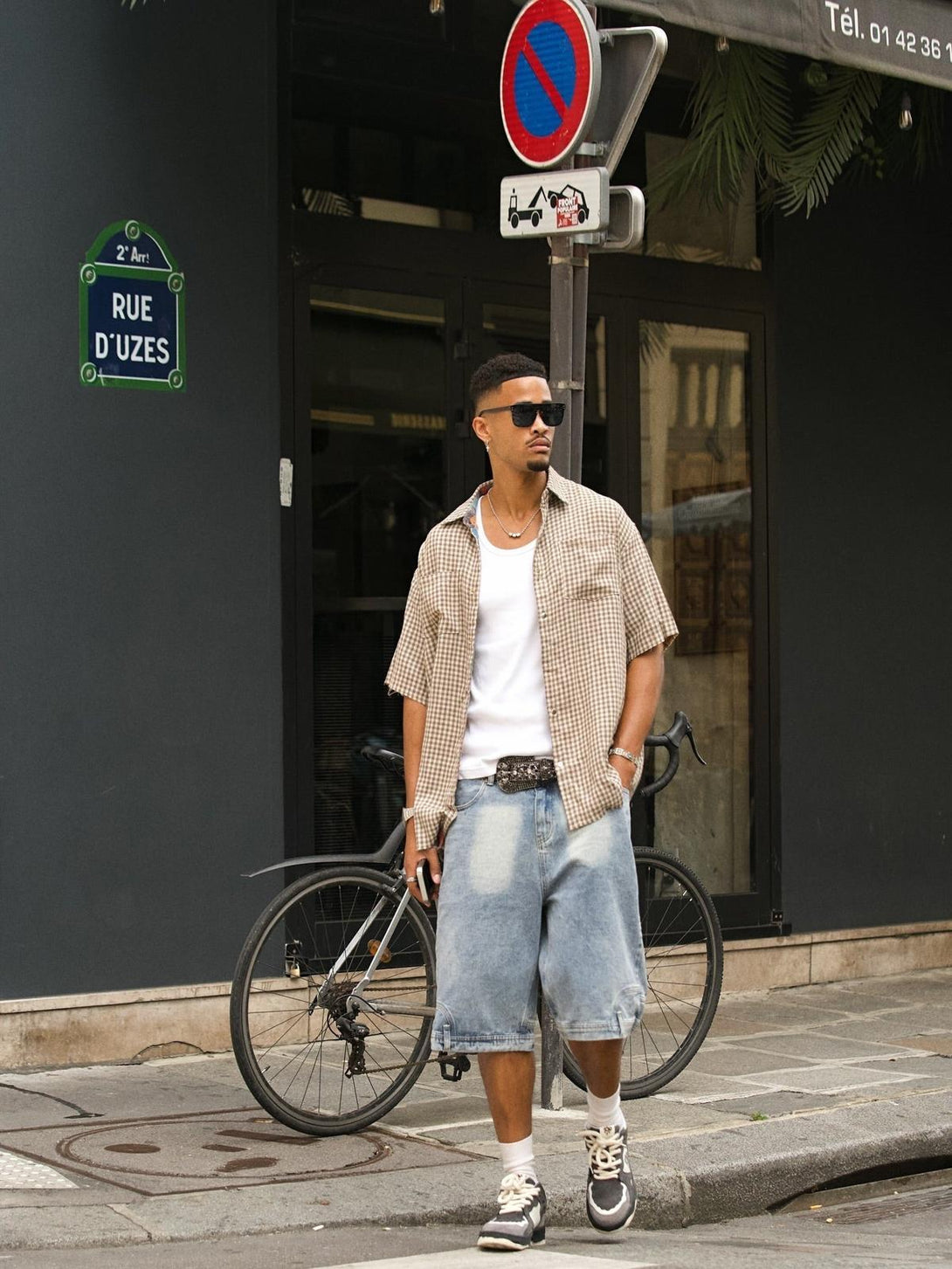 Street style featuring a TALISHKO short-sleeved shirt, paired with denim shorts and sneakers.