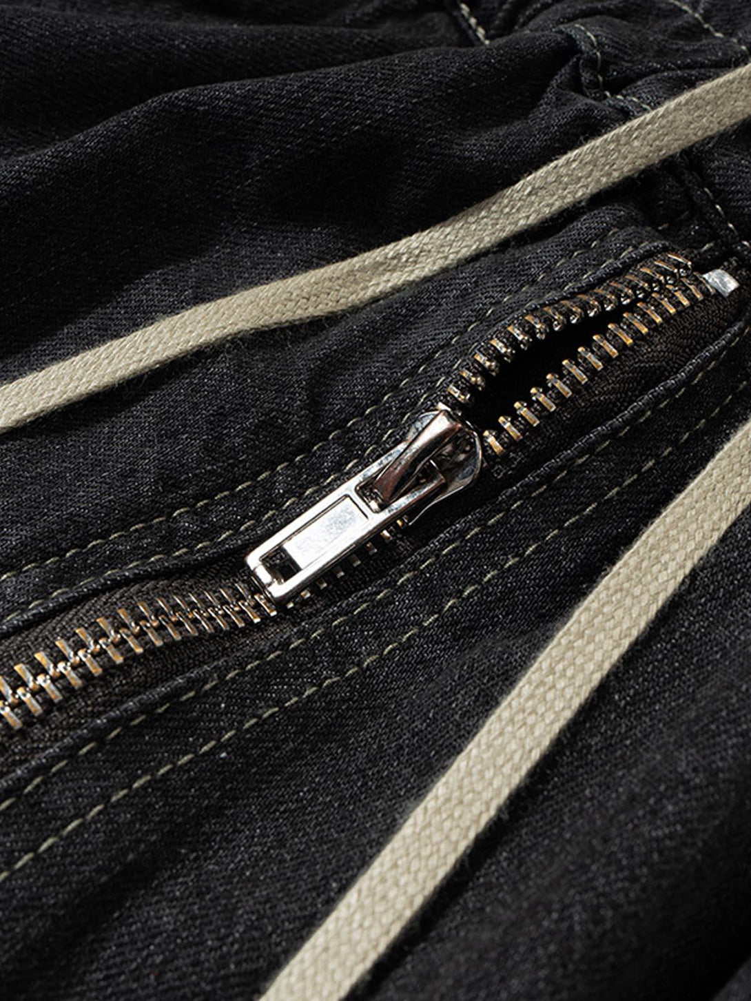Detailed fabric and stitching on TALISHKO's washed denim cargo jort, showcasing zipper design.