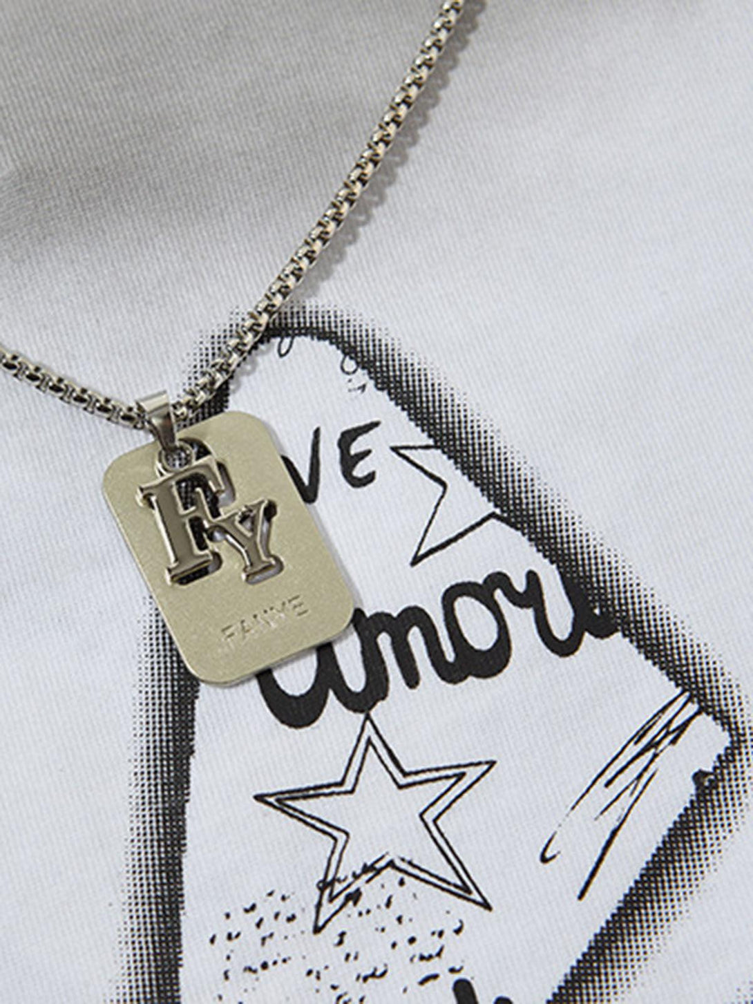 A close-up of a TALISHKO street star graphic vest highlighting the stylish pendant detail.