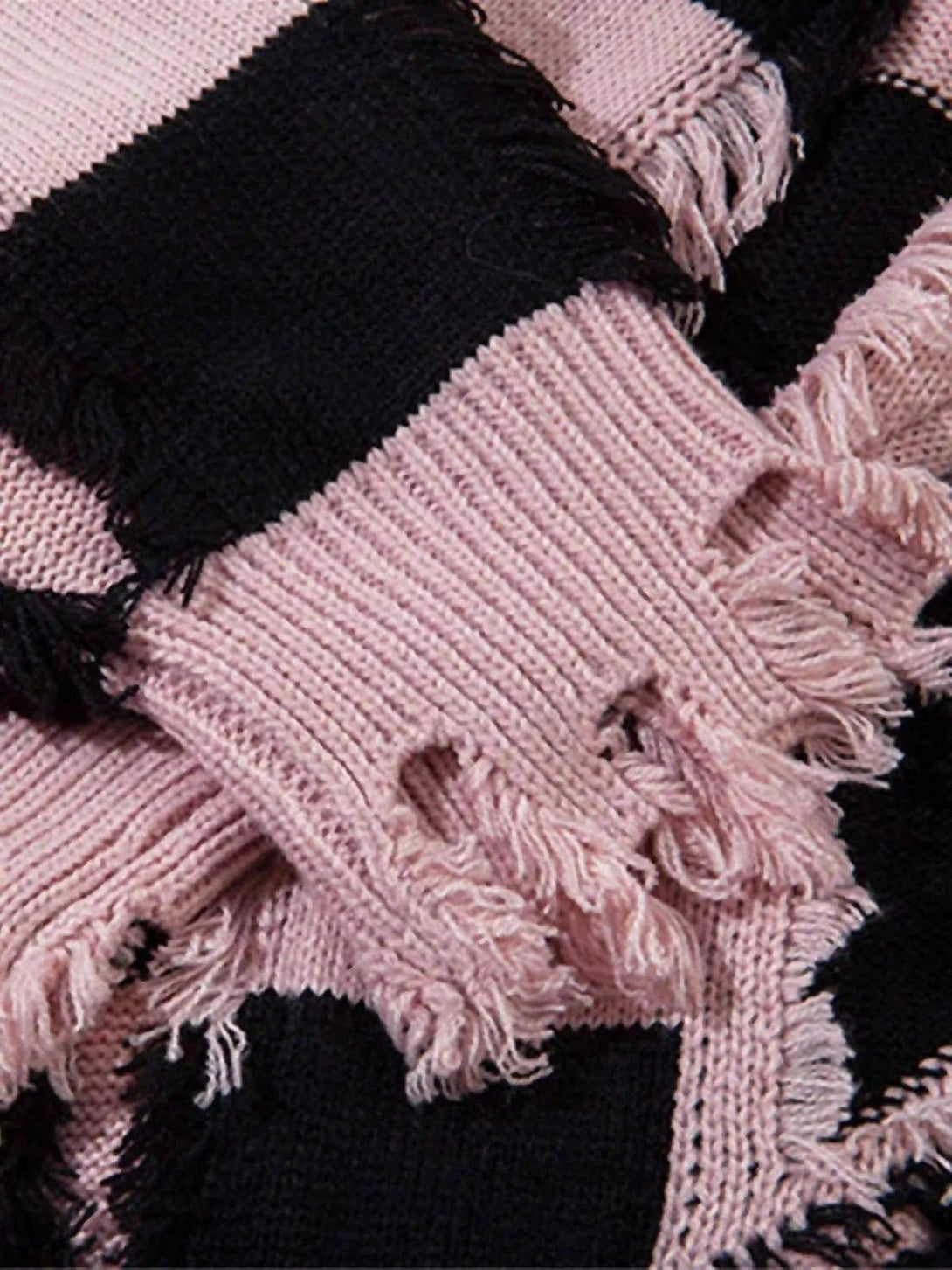 A tight crop highlighting TALISHKO sweater's fringed pink and black stripes with distressed texture.