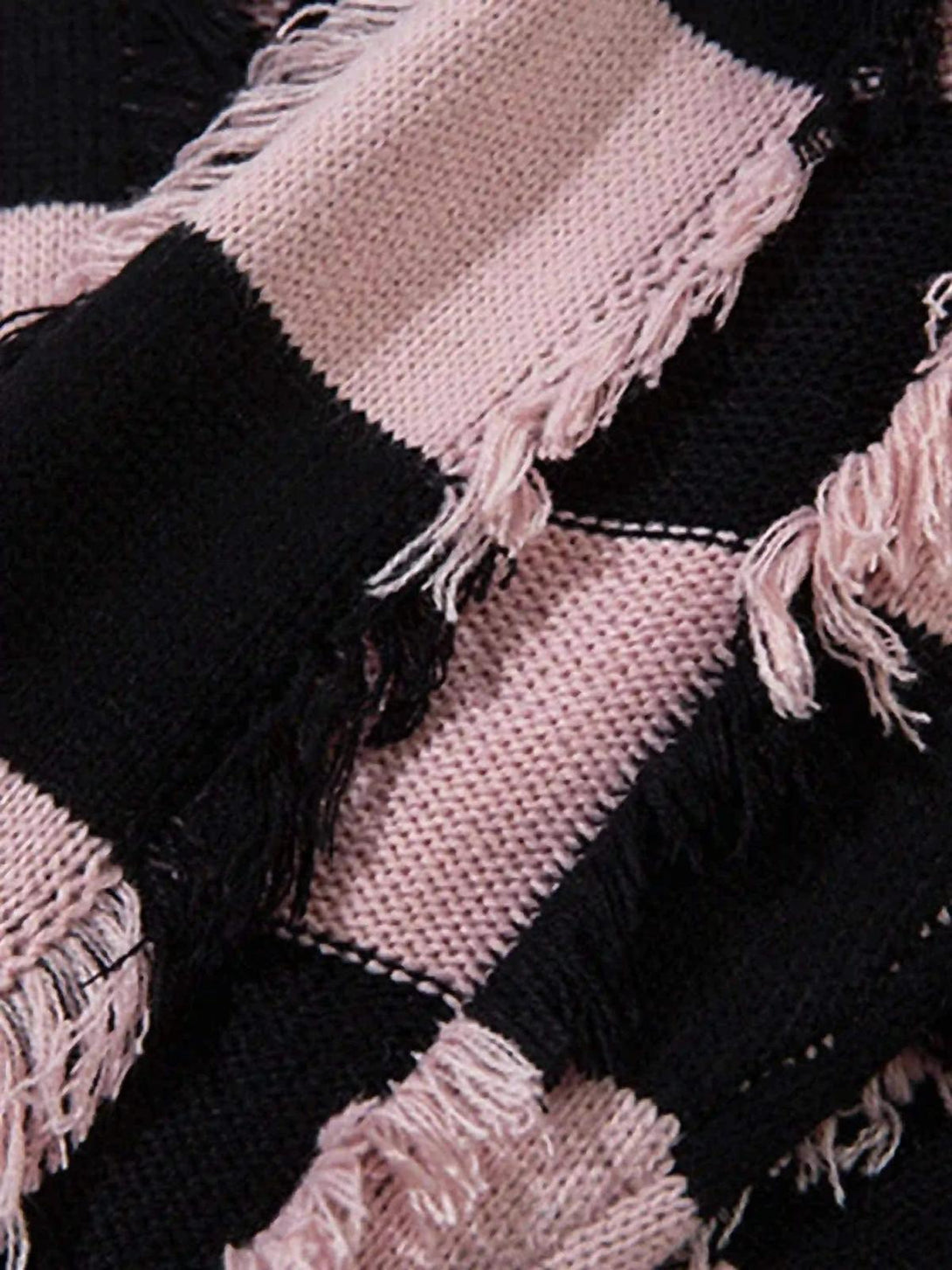 Zoomed-in texture of TALISHKO sweater's pink and black stripes with fringed detailing.