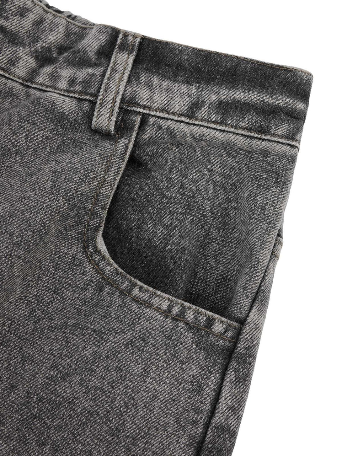 A tight crop highlighting TALISHKO's washed jeans with intricate stitching and durable texture.