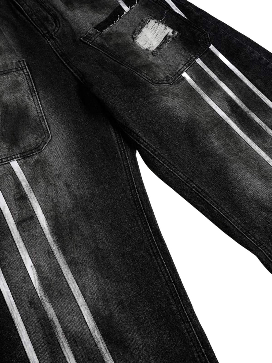 Detailed look at TALISHKO barrel jeans, highlighting distressed patch and stripe accents.