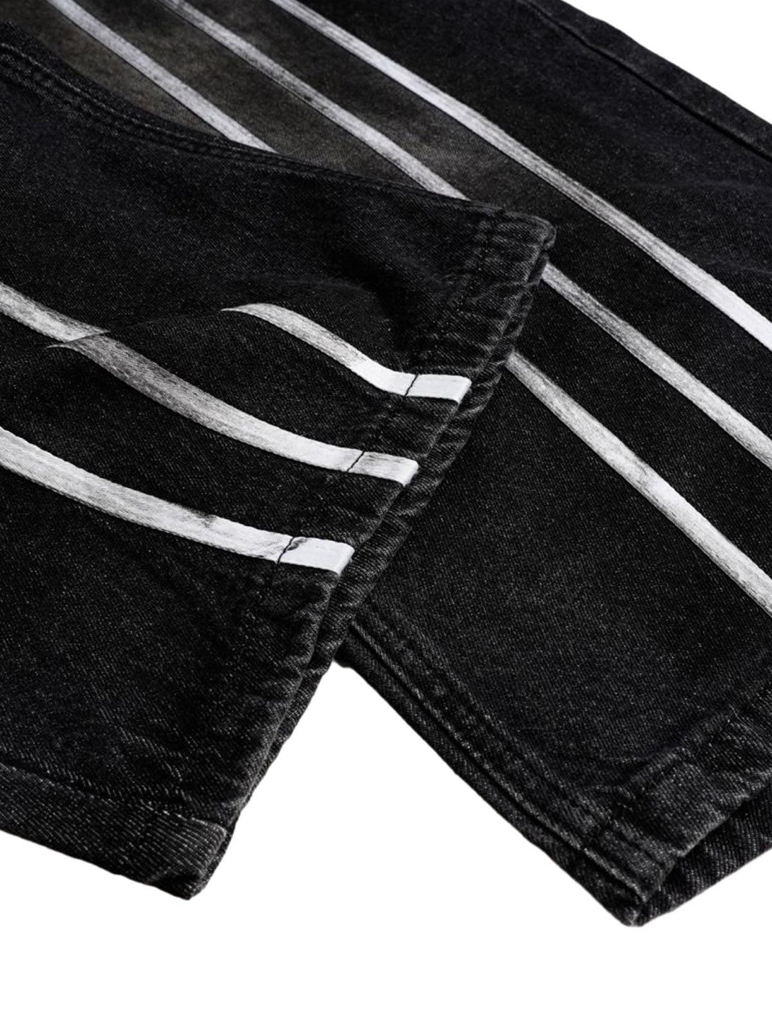 Stripe detail on black barrel jeans by TALISHKO, showcasing unique dye effect and texture.