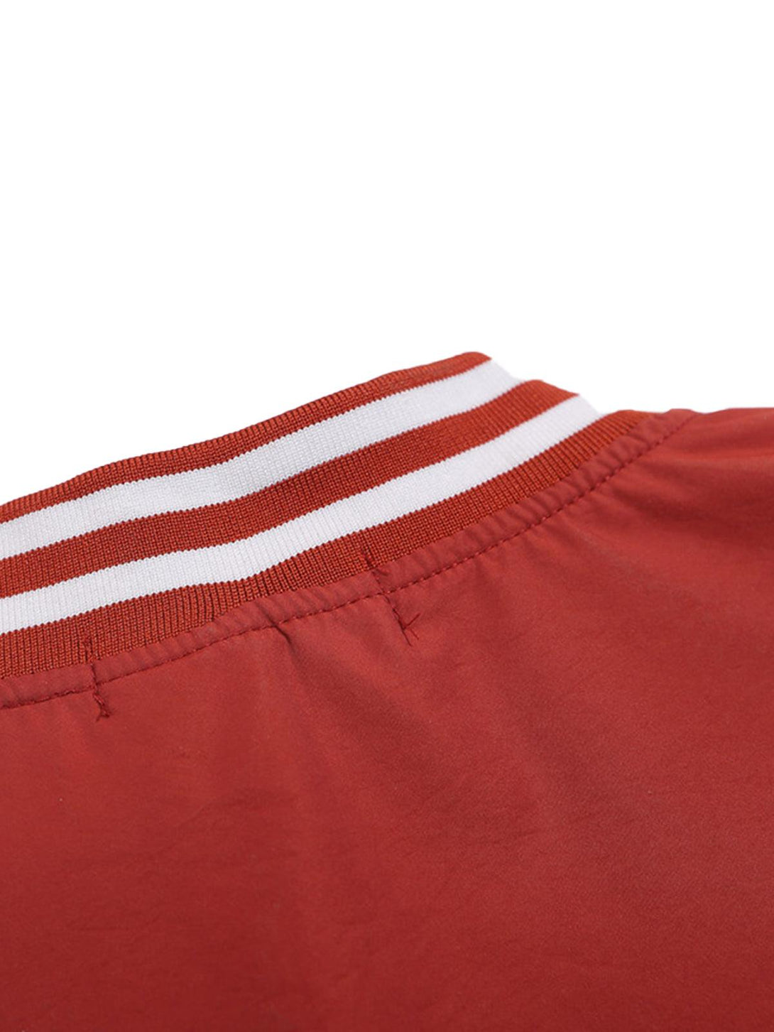 Focusing on the striped collar detail of a red V-neck baseball-inspired sweatshirt by TALISHKO.