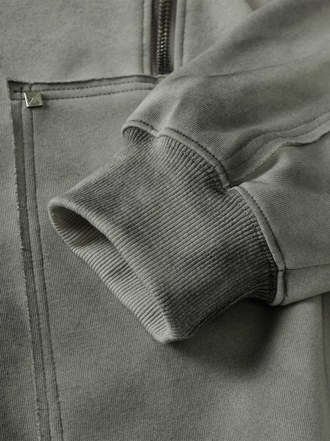 Intricate look at the cuff and rivet details on a TALISHKO hooded jacket, showcasing its texture.