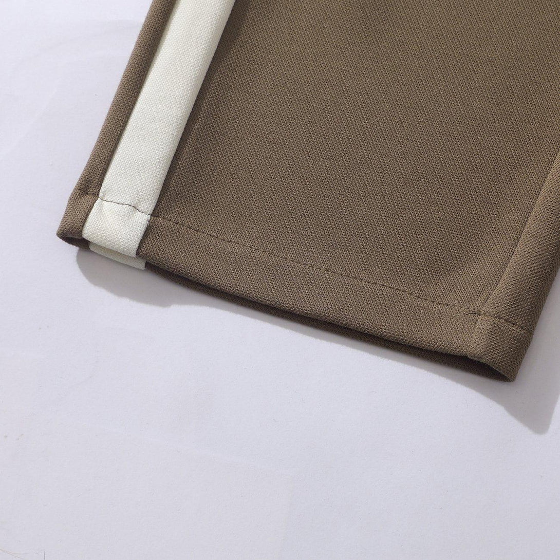 Detailed fabric and stitching of TALISHKO striped patchwork pants, featuring a brown and white design.