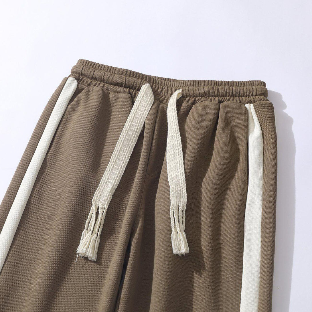 Focused view of TALISHKO striped patchwork pants, highlighting the brown fabric and drawstring.