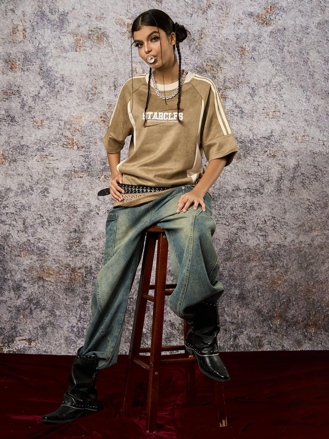 Model in a TALISHKO oversized T-shirt with suede contrast, styled with denim and studded belt.