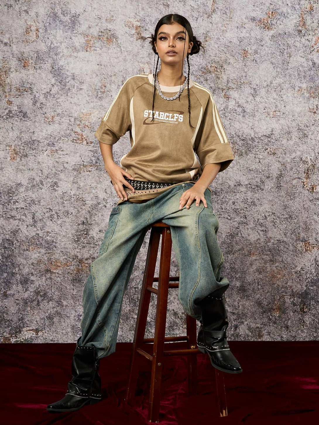 Model in a TALISHKO oversized T-shirt with suede contrast, styled with studded belt and boots.