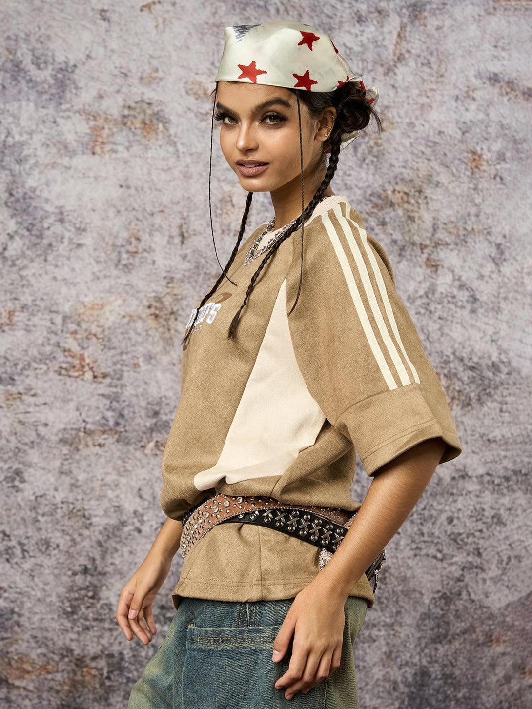 Model in a TALISHKO oversized T-shirt with suede contrast, styled with a studded belt and headscarf.