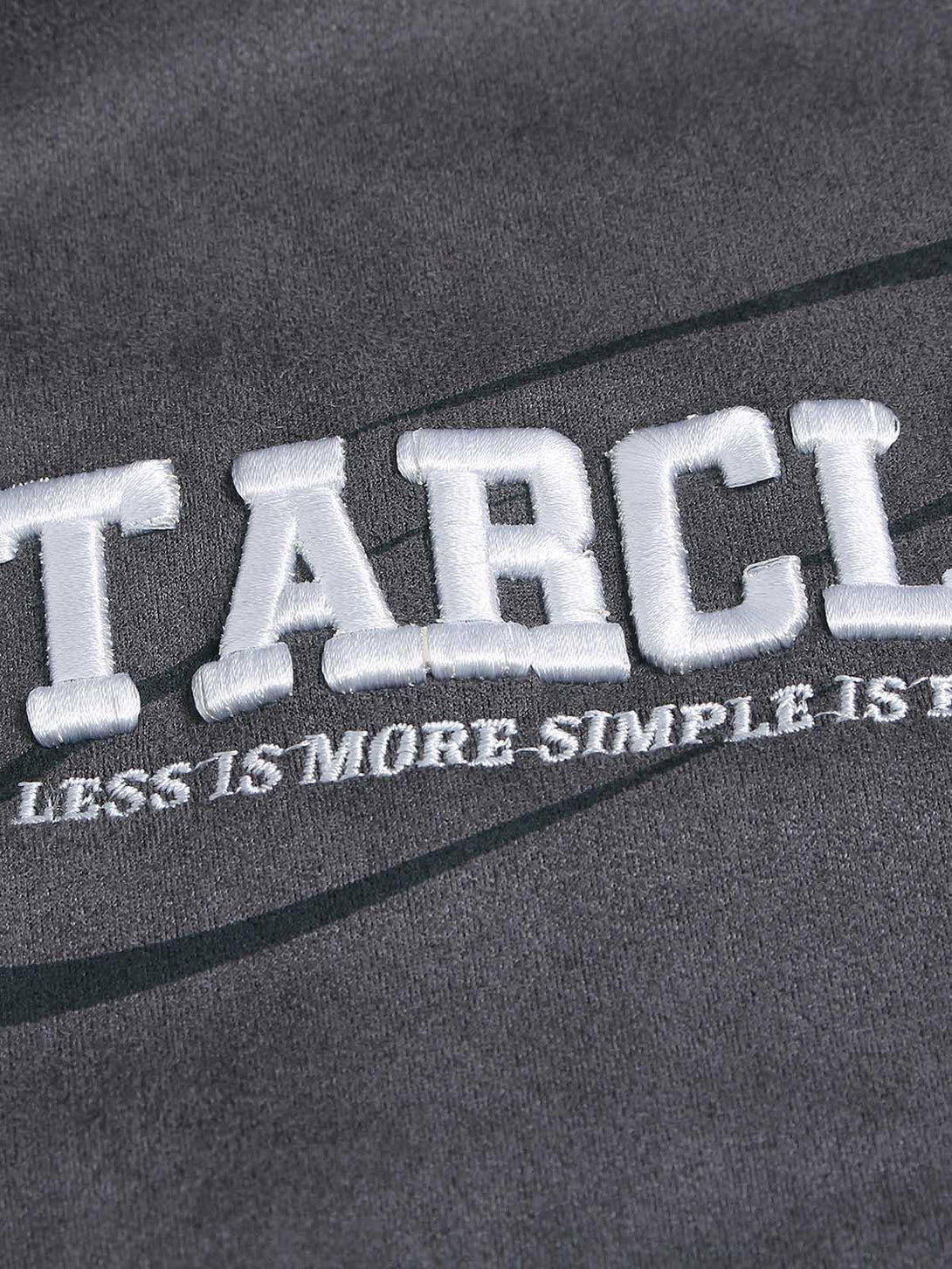 Detailed view of TALISHKO T-shirt, highlighting letter embroidery on soft fabric.