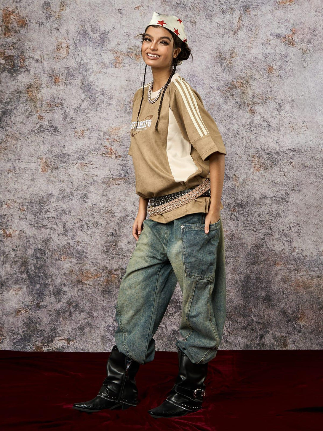 Model in a TALISHKO oversized T-shirt with suede contrast, paired with denim and boots.