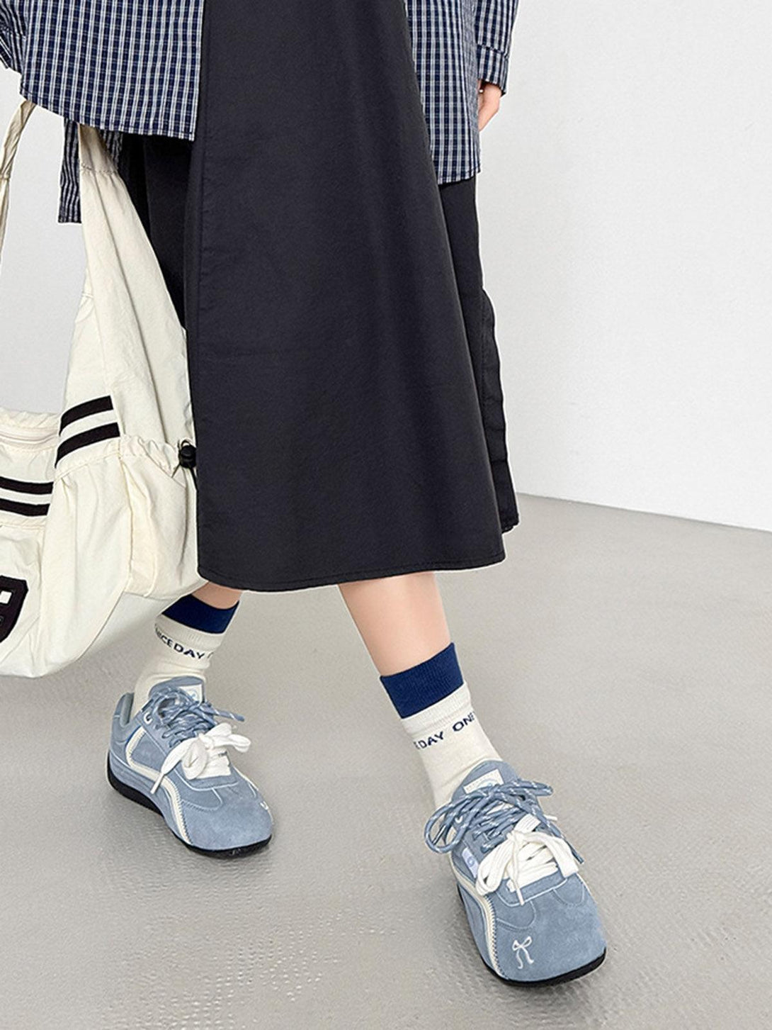 Blue suede lace-up sneakers by TALISHKO paired with a casual outfit, highlighting street style.