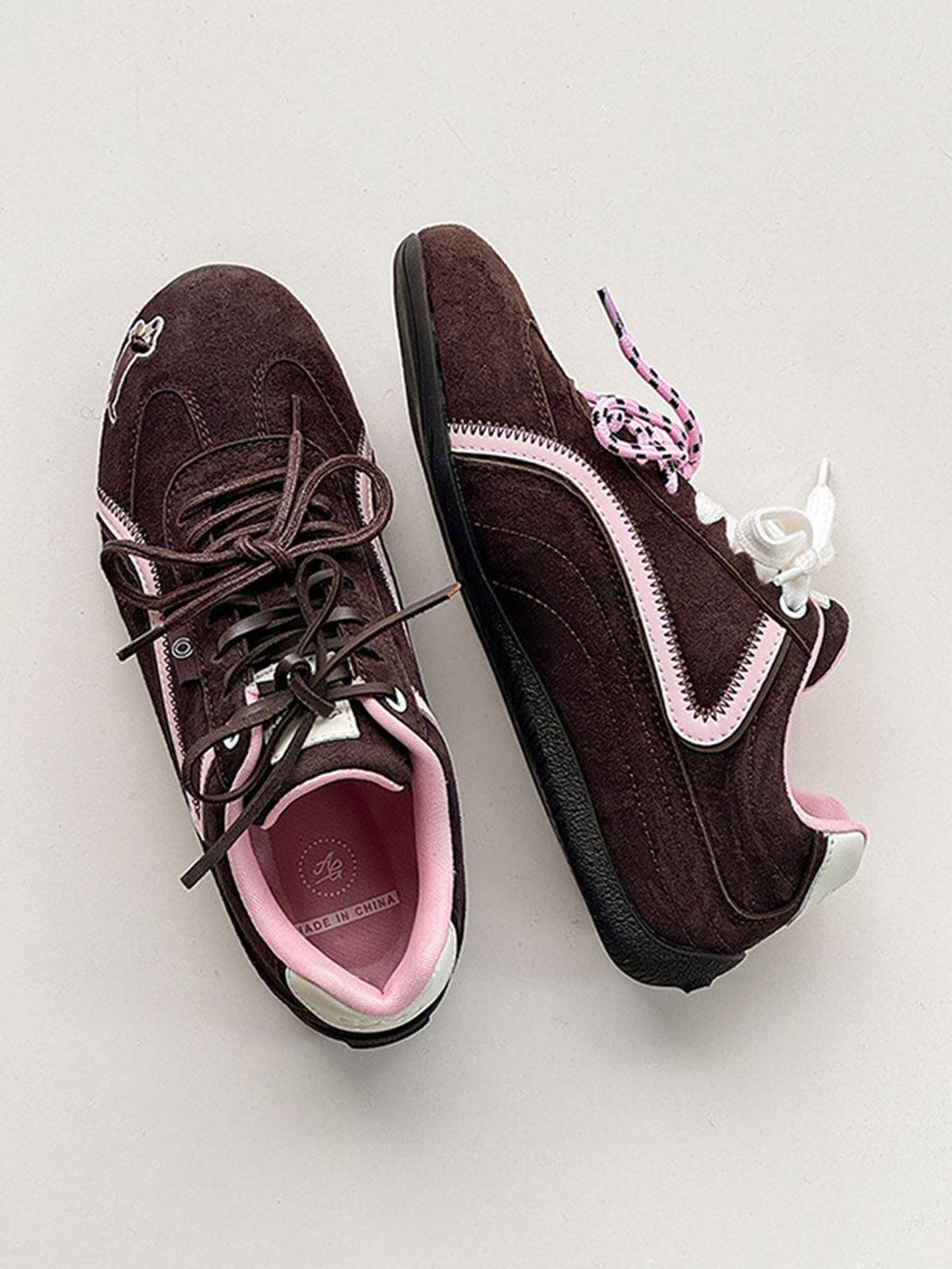 Brown suede lace-up sneakers by TALISHKO, featuring playful embroidery and contrasting laces.